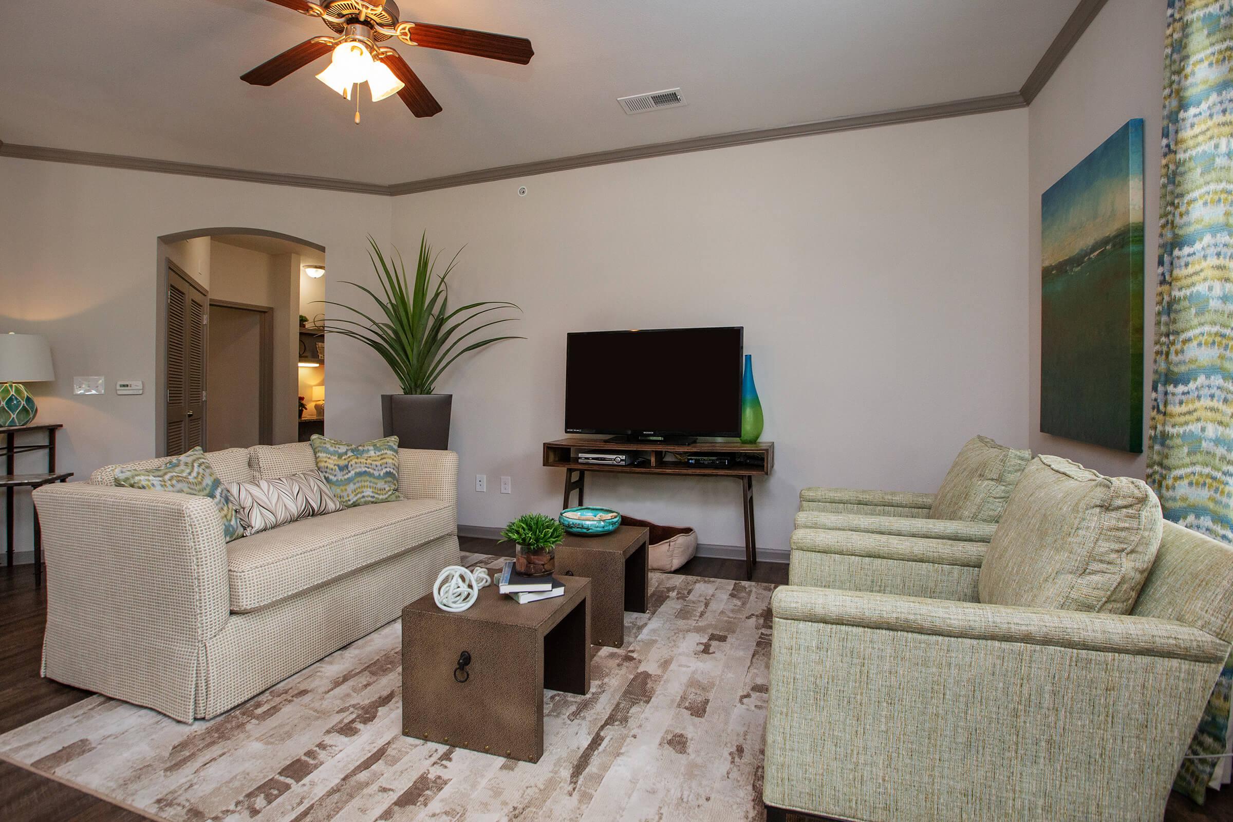 a living room filled with furniture and a flat screen tv