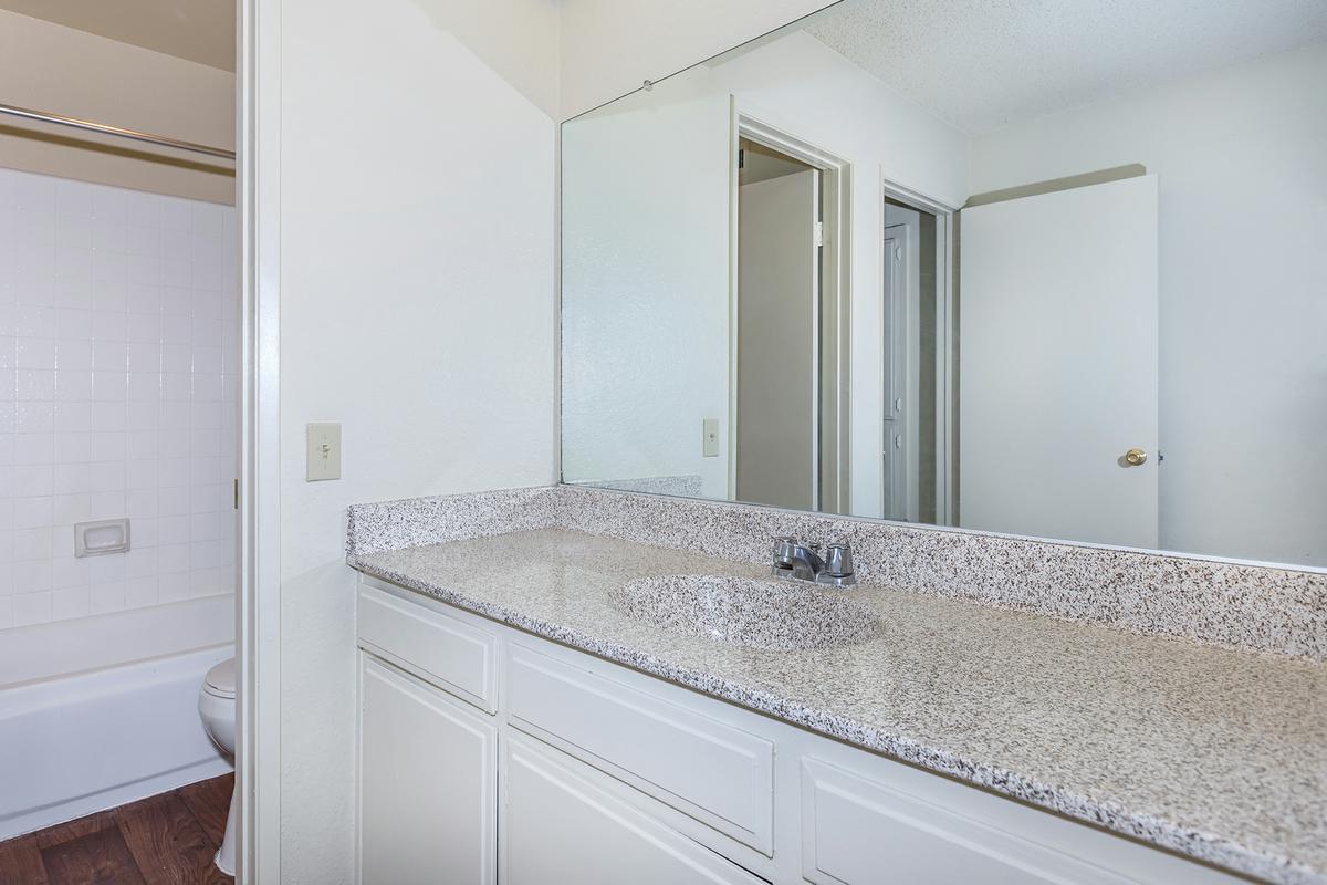 Bathroom sink and mirror with white cabinets