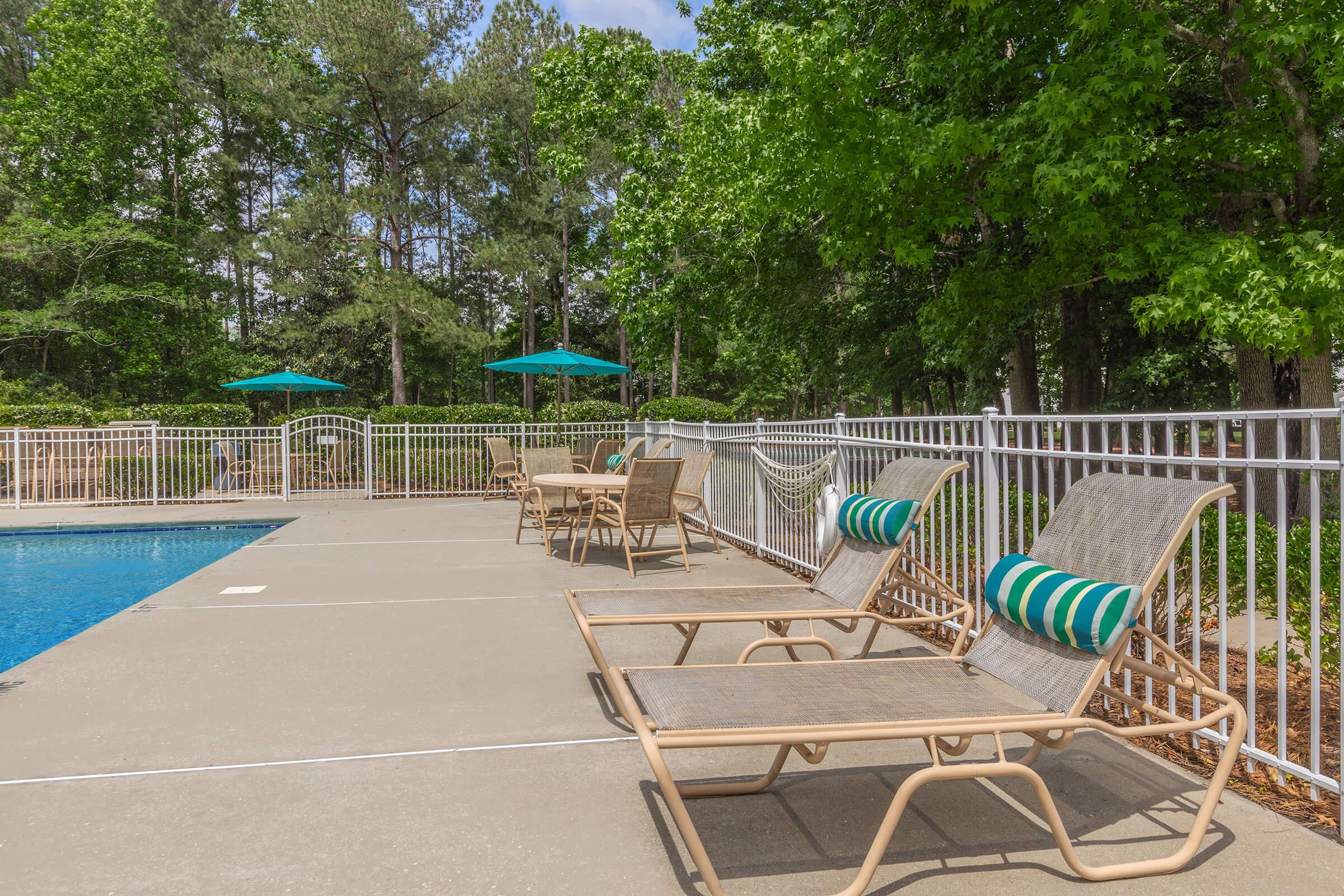 a person sitting on a bench next to a pool