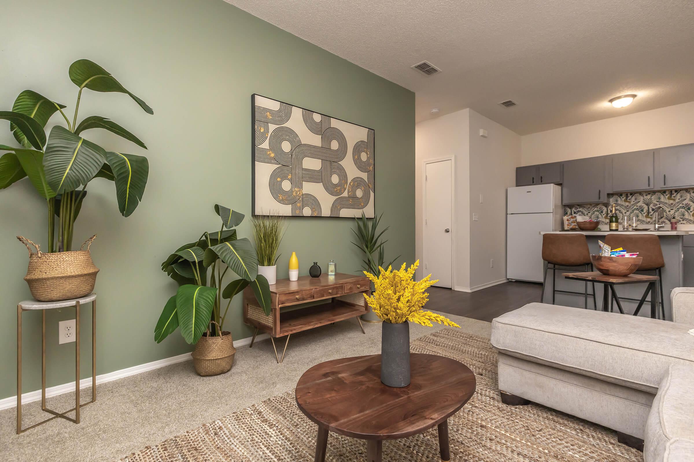 a living room filled with furniture and vase of flowers on a table