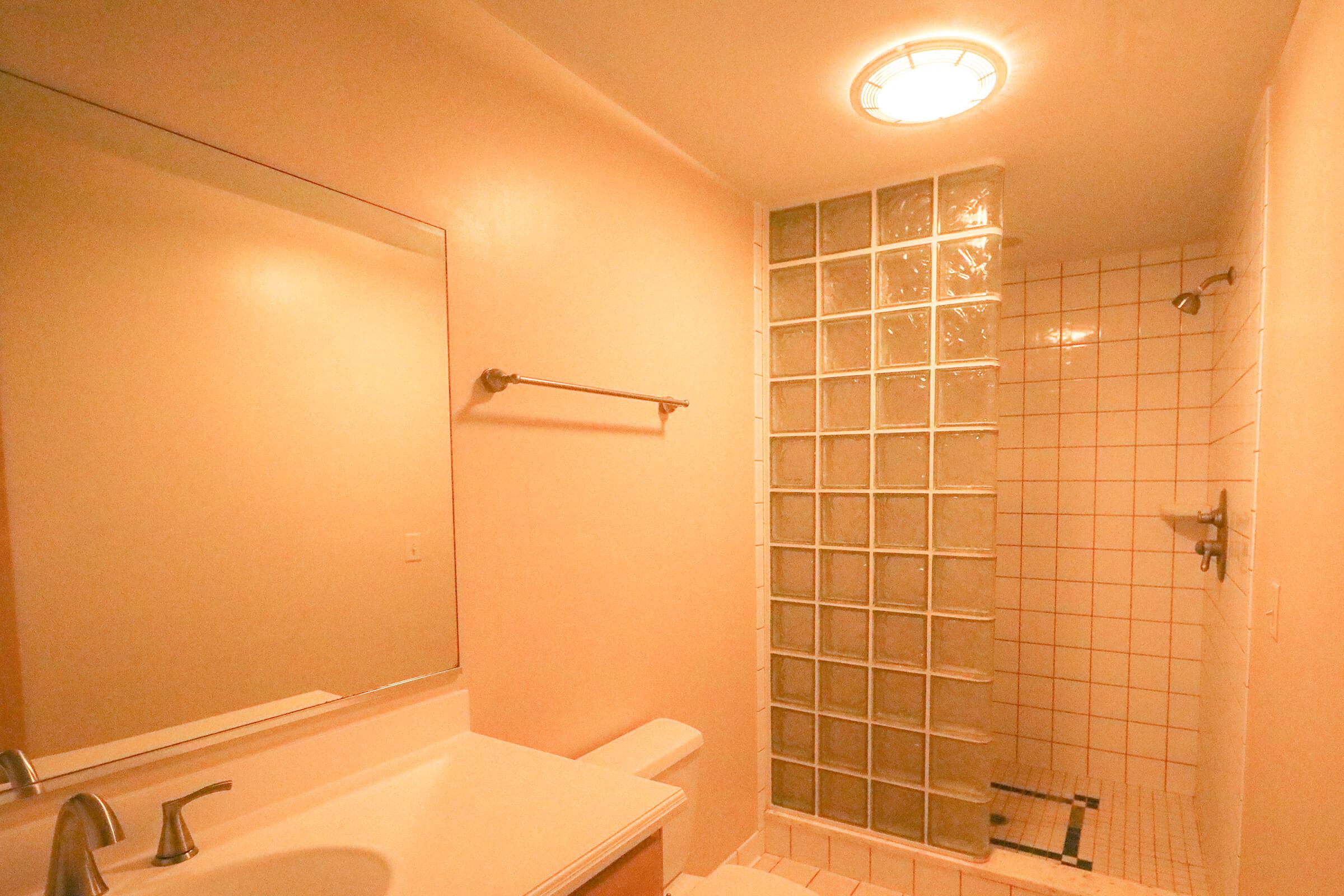 a white sink sitting next to a shower