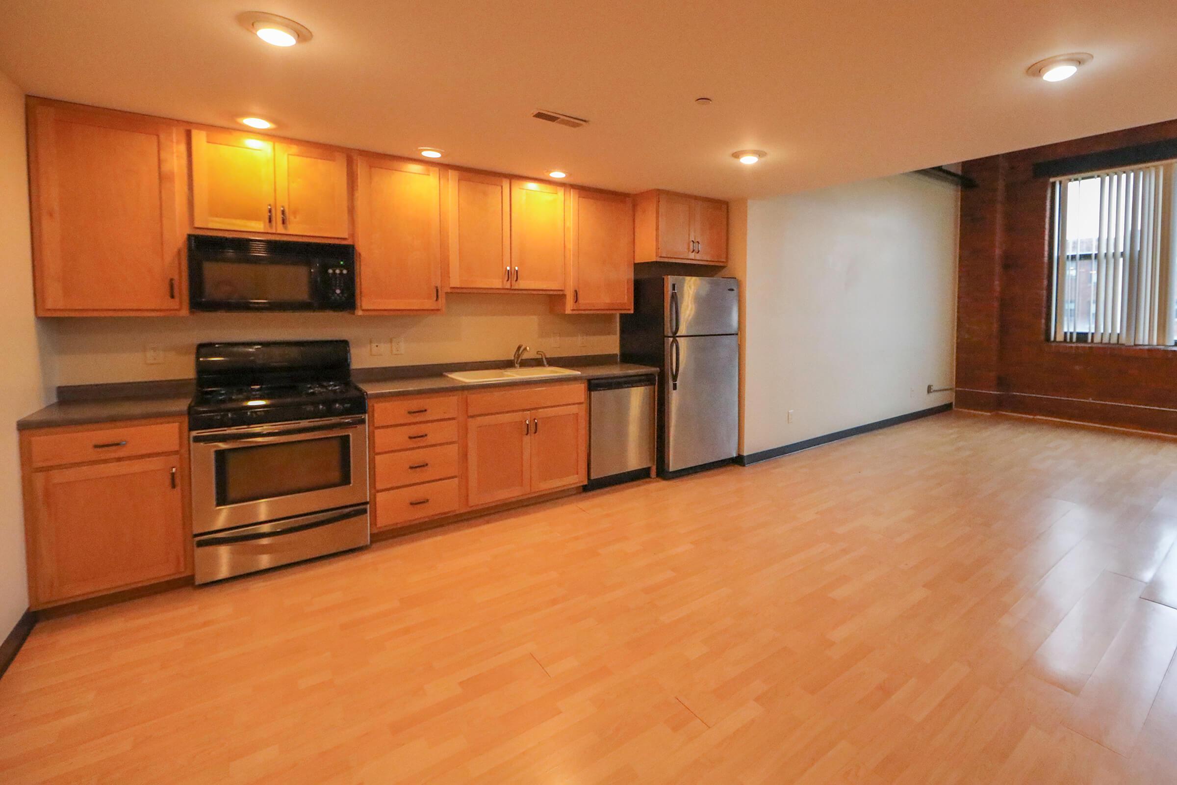 a large kitchen with stainless steel appliances and wooden cabinets