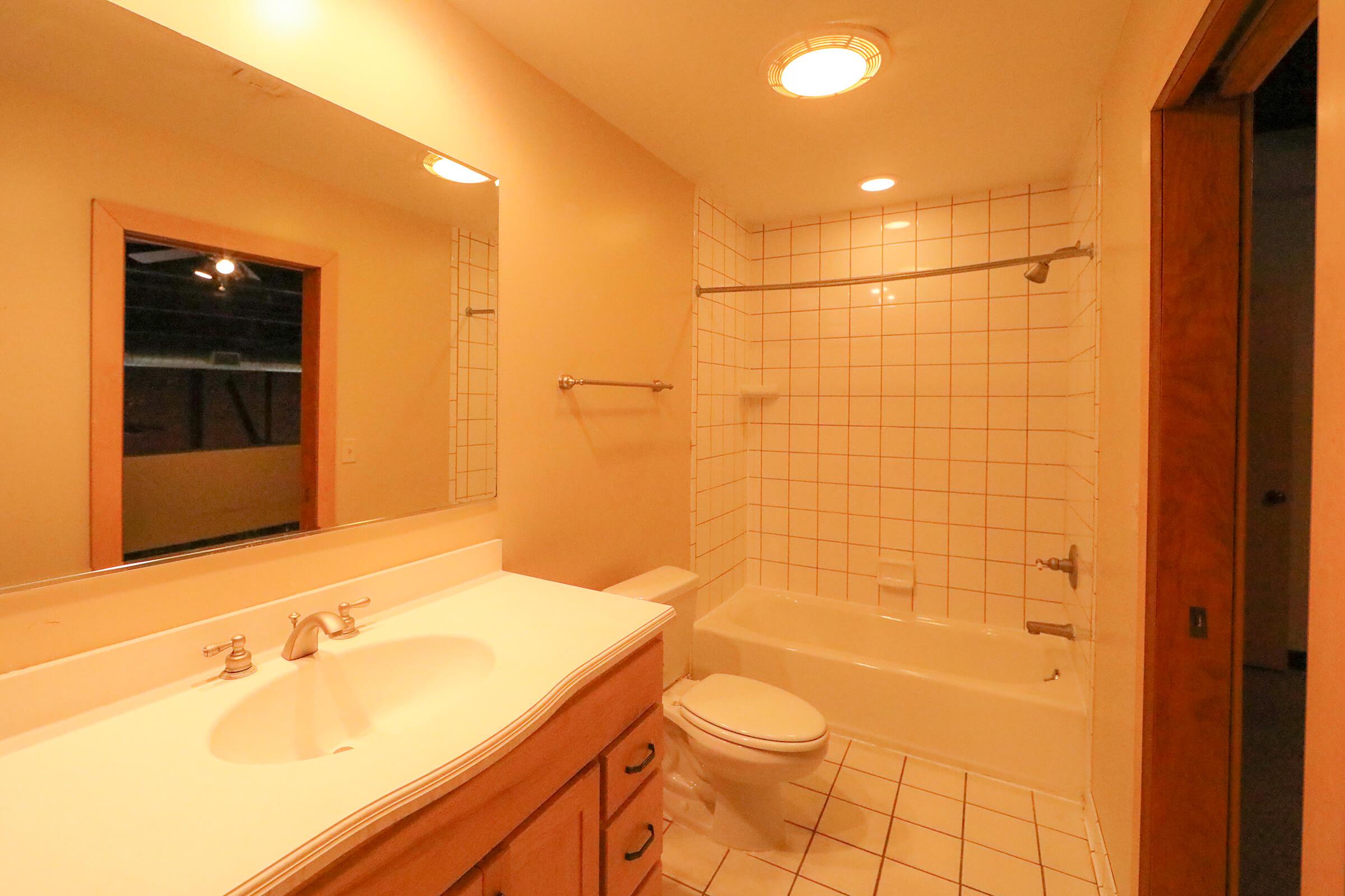 a white sink sitting under a mirror