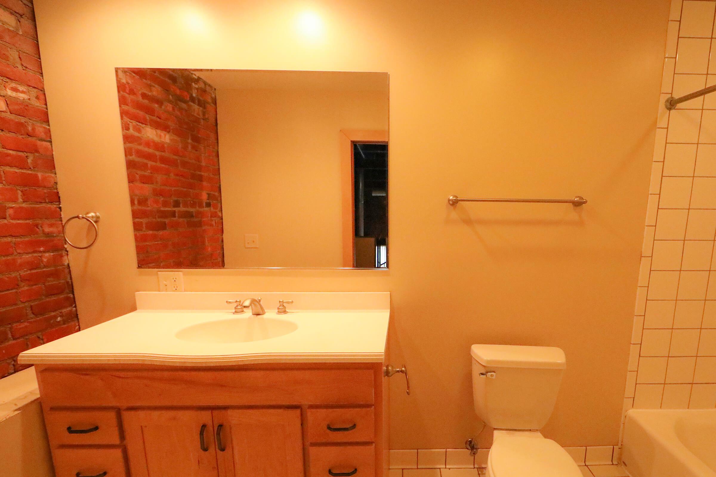 a white sink sitting under a mirror