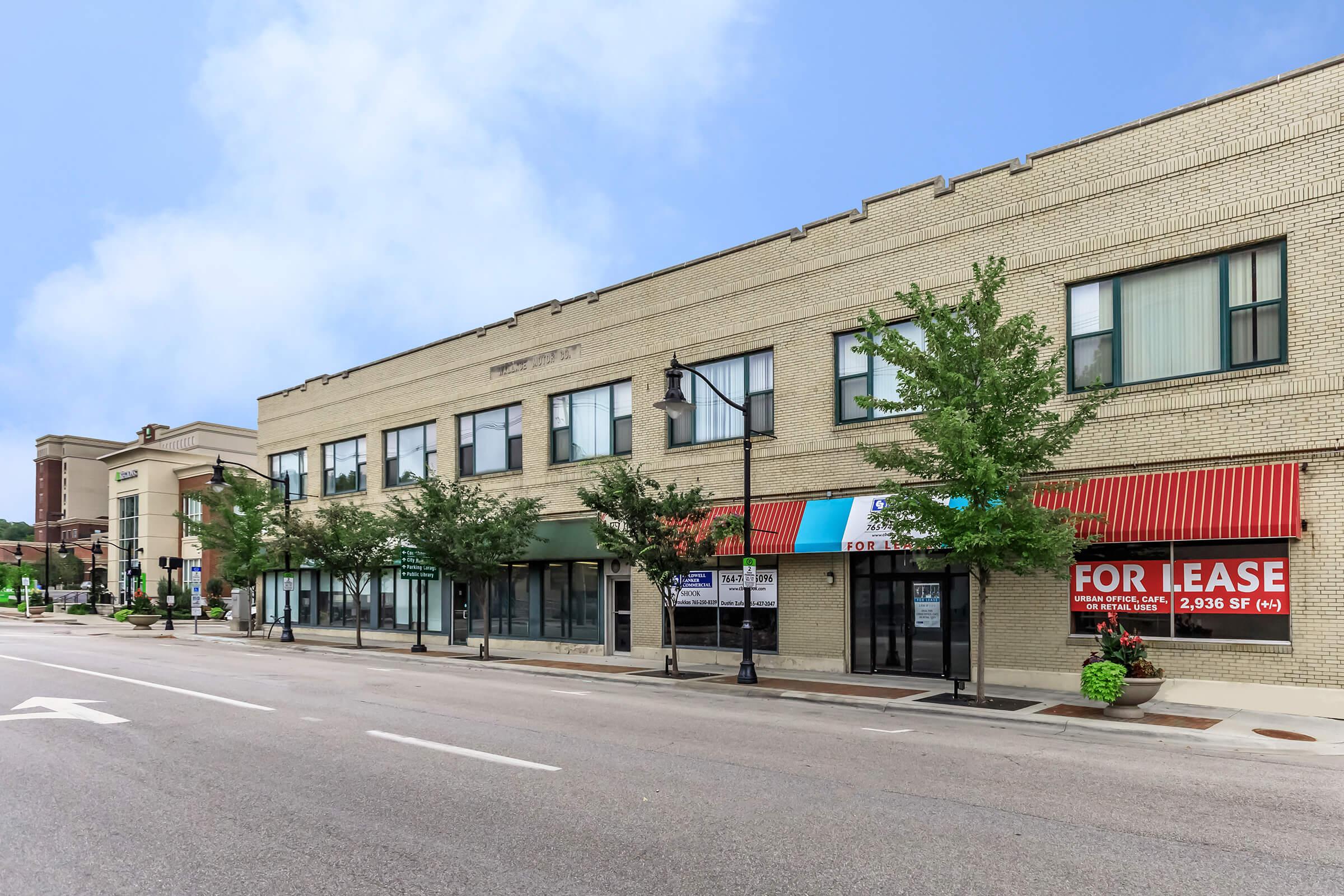 a large brick building with a store on the side of a road