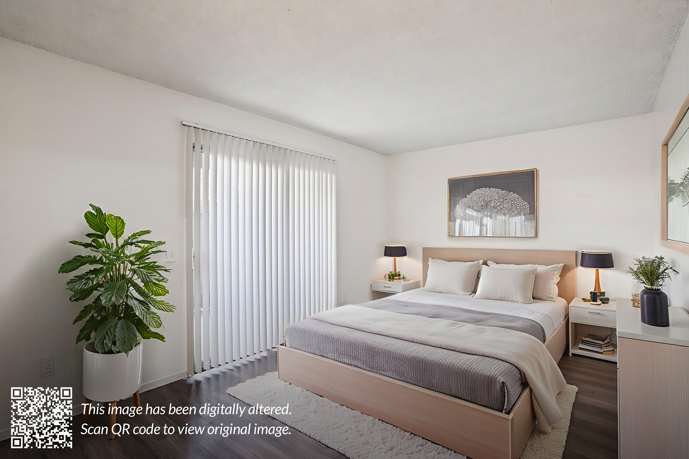 A modern bedroom featuring a queen-sized bed with gray and white bedding, two bedside lamps, a large planter with greenery, and a framed artwork above the bed. The room has white walls and a large window covered by vertical blinds, allowing natural light to illuminate the space. A QR code is visible in the corner, indicating the image has been digitally altered.