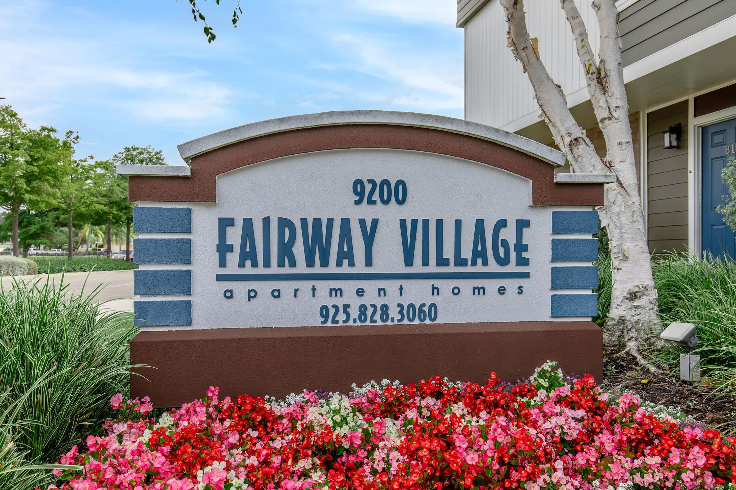 a sign above a flower garden