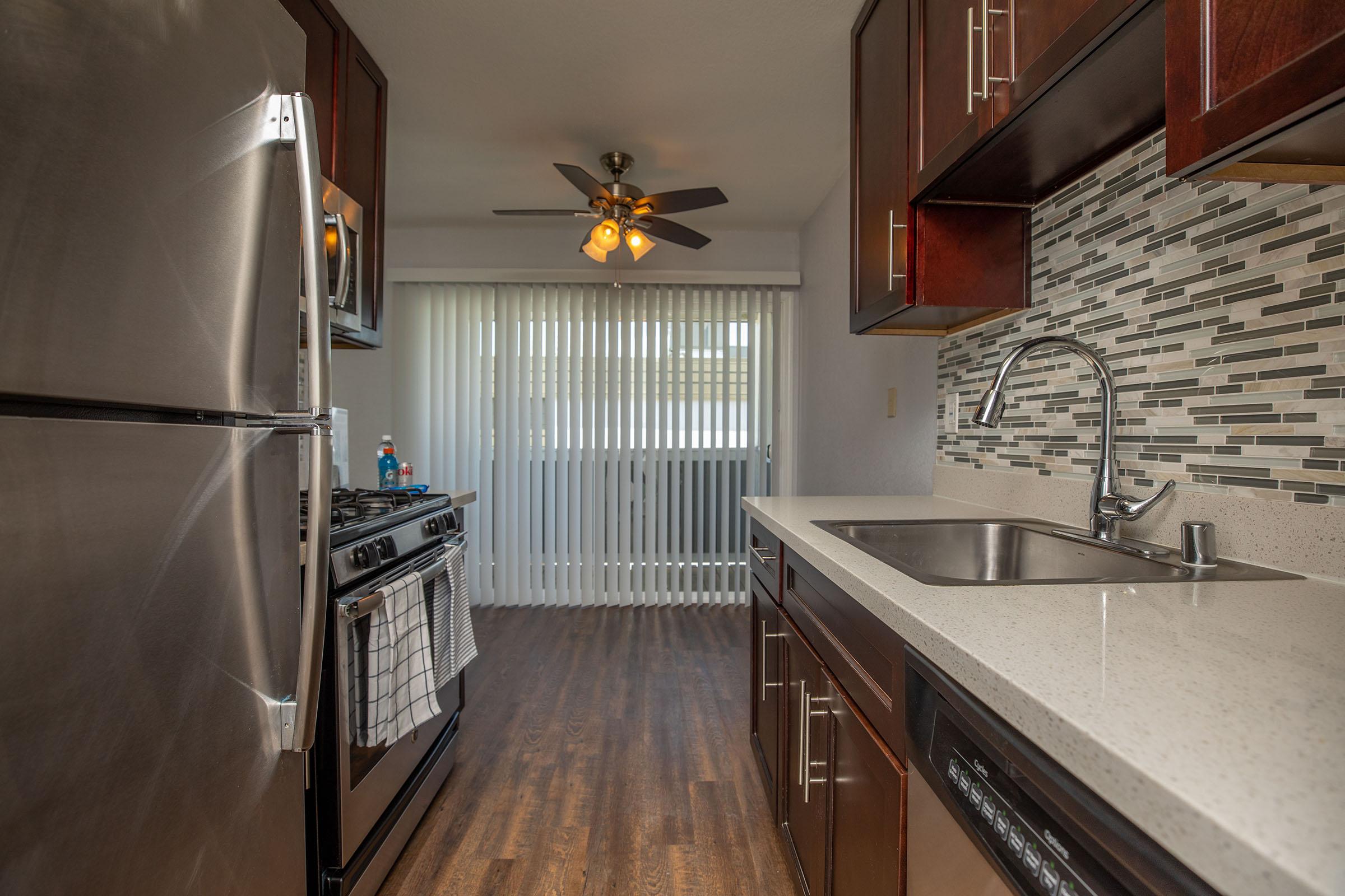 a kitchen with stainless steel appliances and wooden cabinets