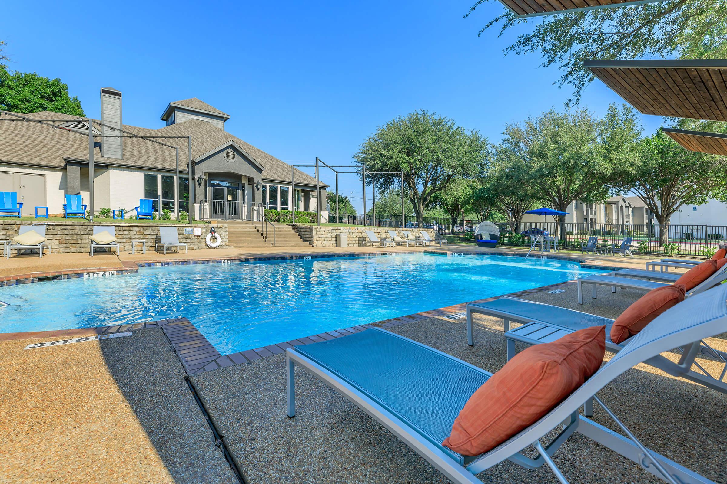 a group of lawn chairs sitting on top of a swimming pool