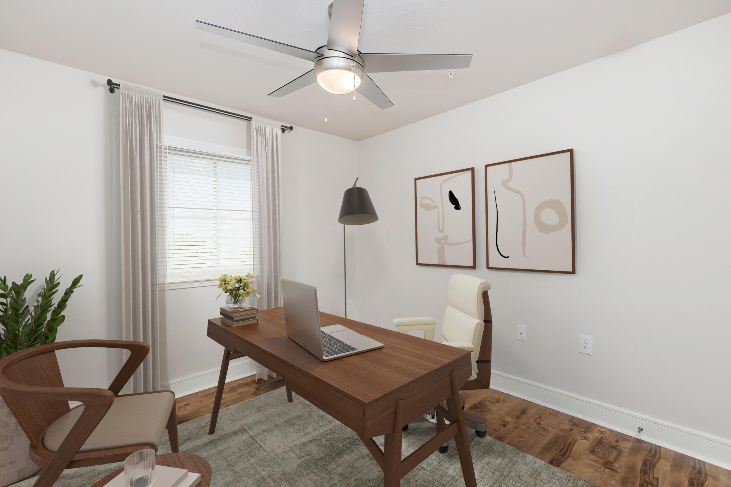 A modern home office featuring a wooden desk with a laptop, a comfortable chair, and a stylish floor lamp. Light curtains frame a window that lets in natural light. Two abstract art pieces adorn the wall, and a potted plant adds a touch of greenery to the minimalist space.