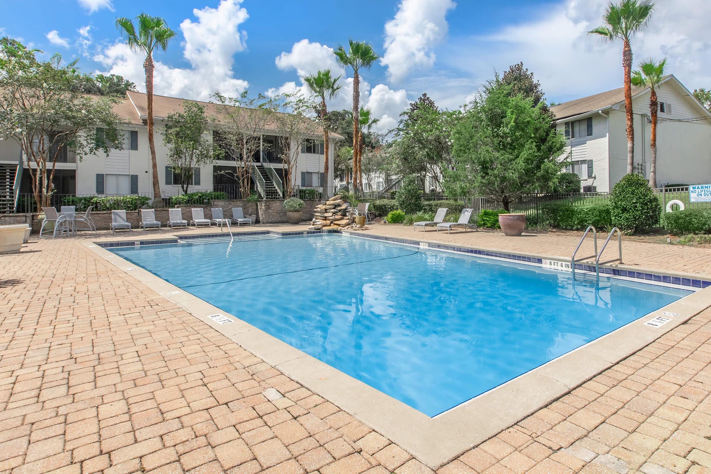 a house with a pool in front of a brick building