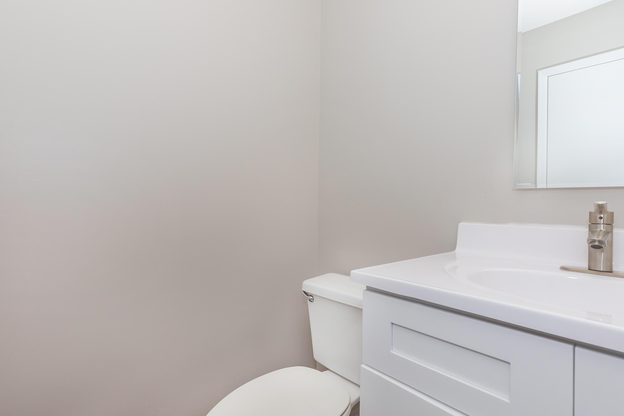 a white sink sitting under a mirror