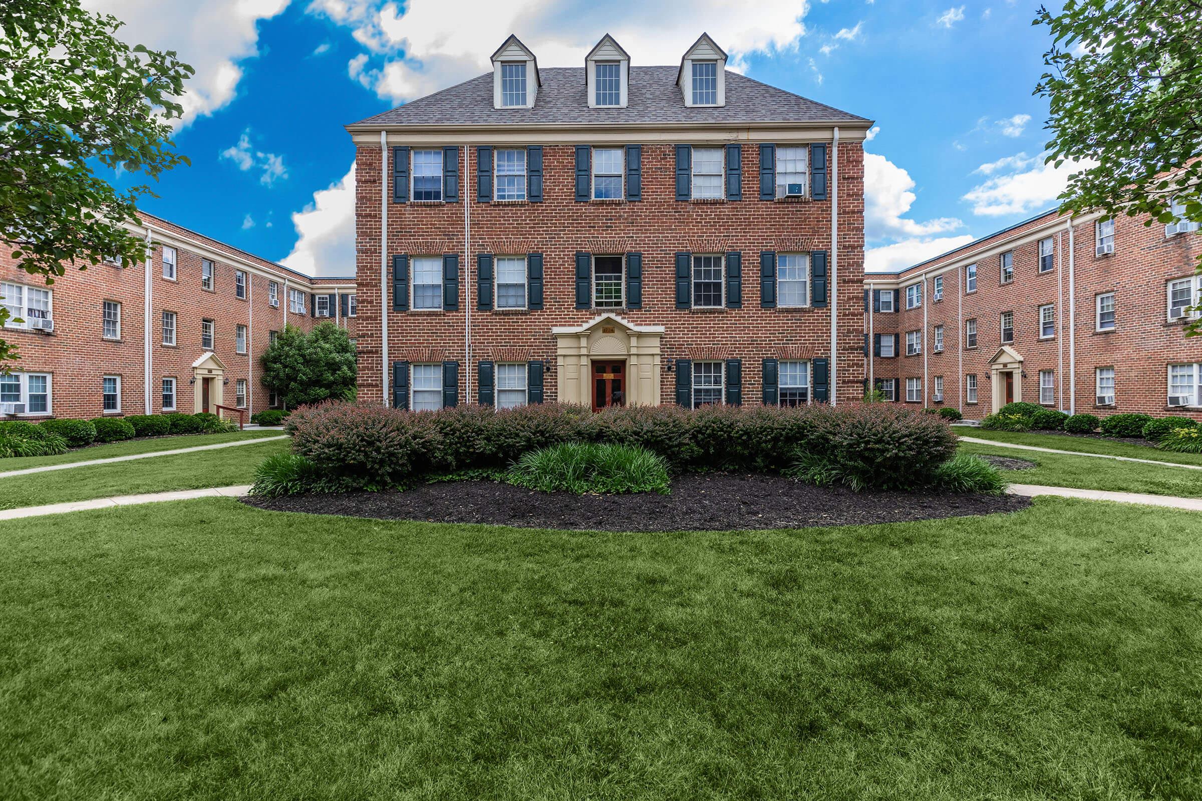 a large lawn in front of a brick building