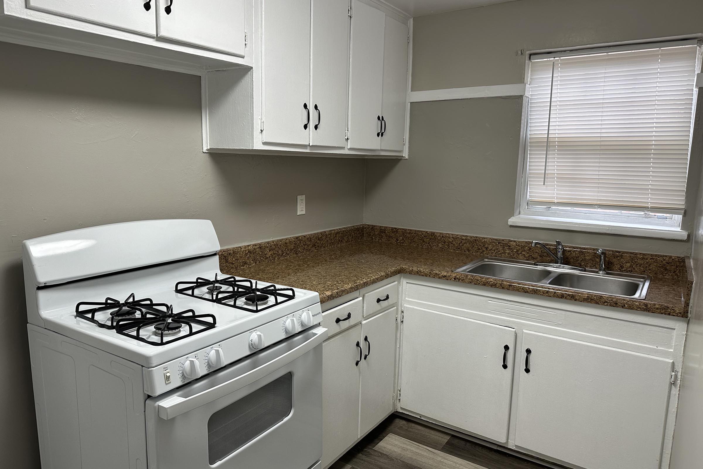 a stove top oven sitting inside of a kitchen