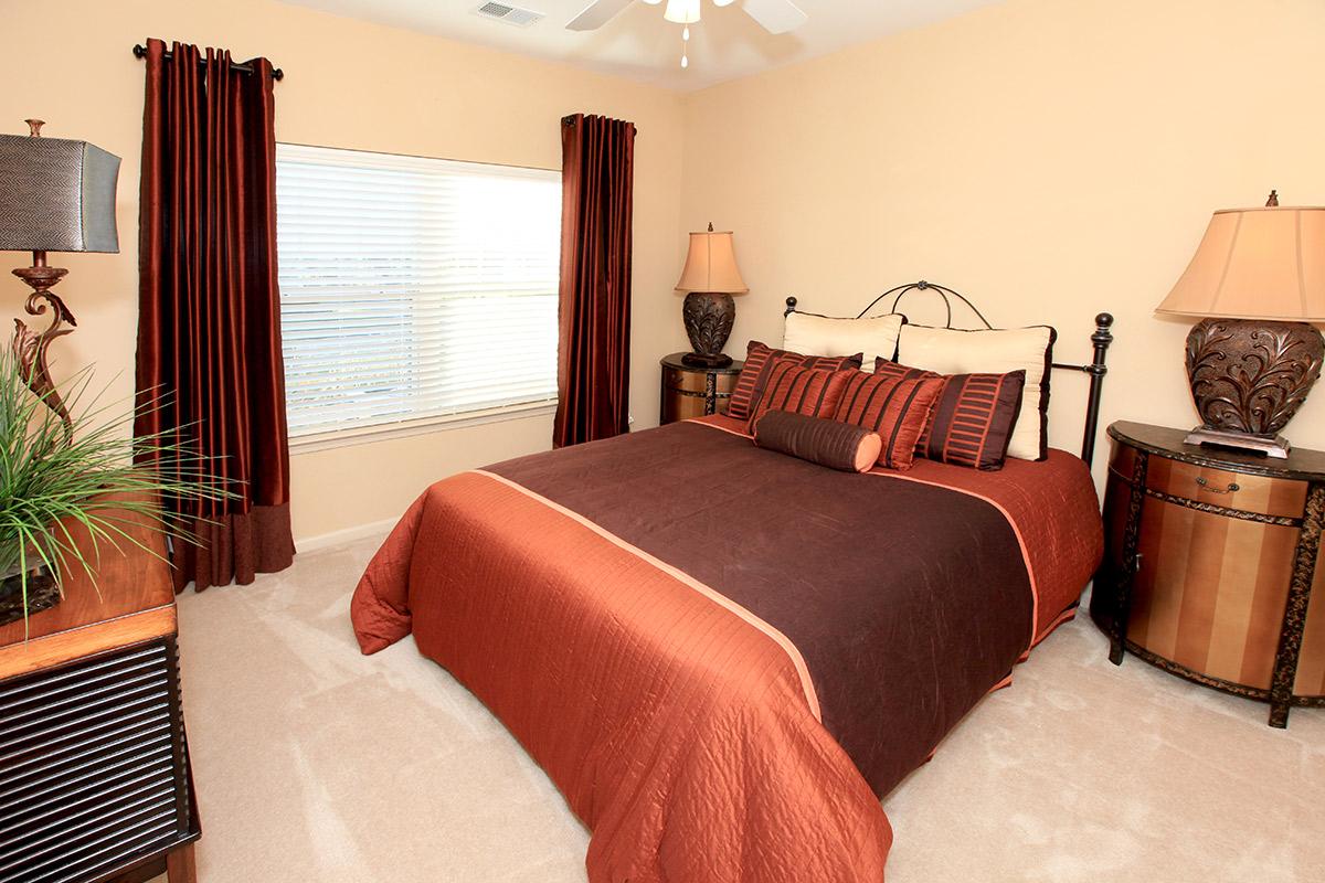 a bedroom with a large red chair in a room