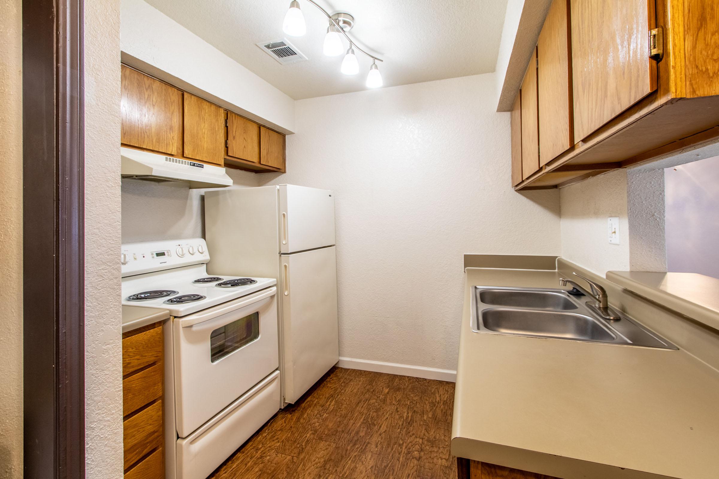 a kitchen with a stove sink and refrigerator