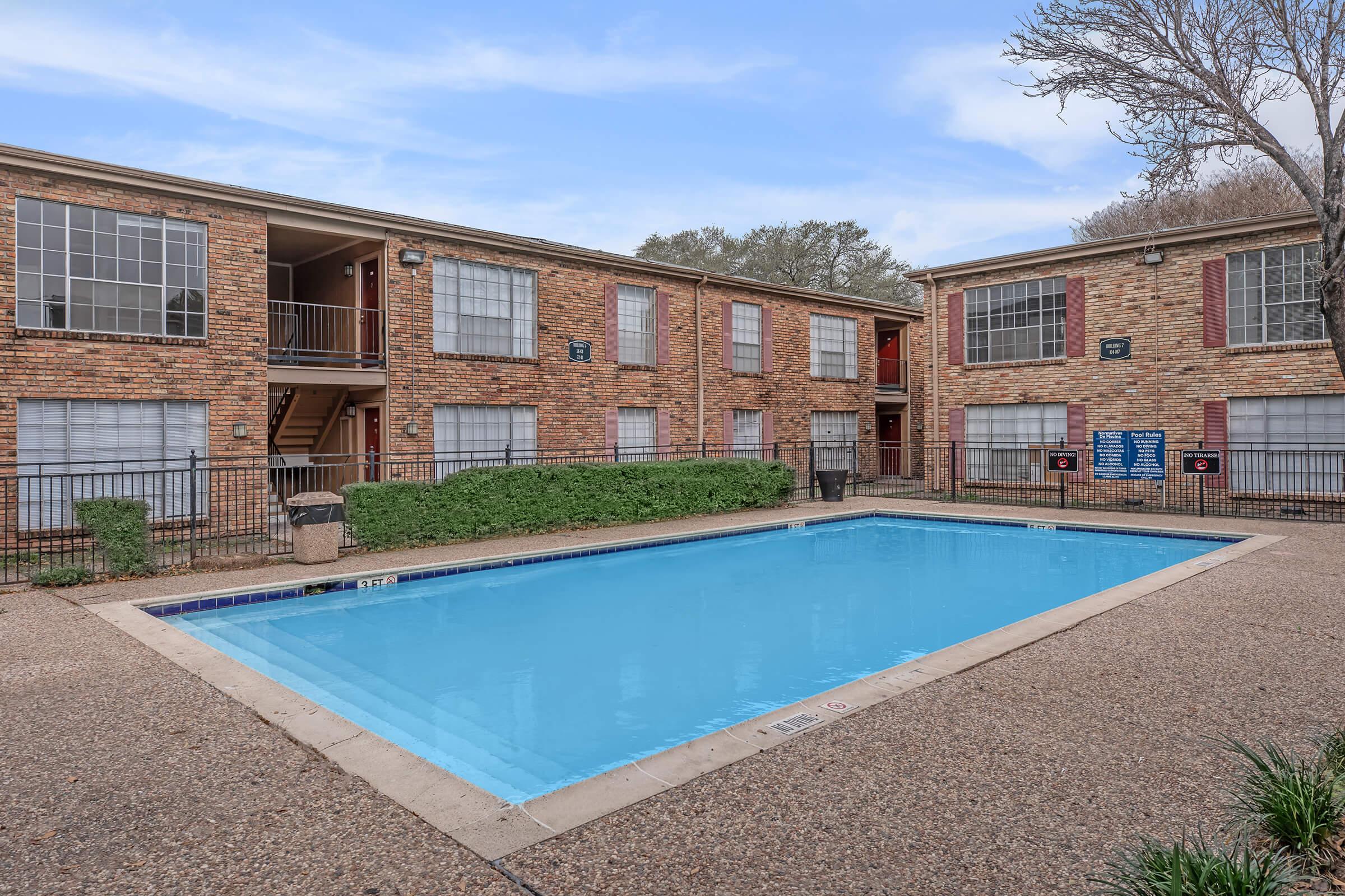 a large brick building with a pool in front of a house