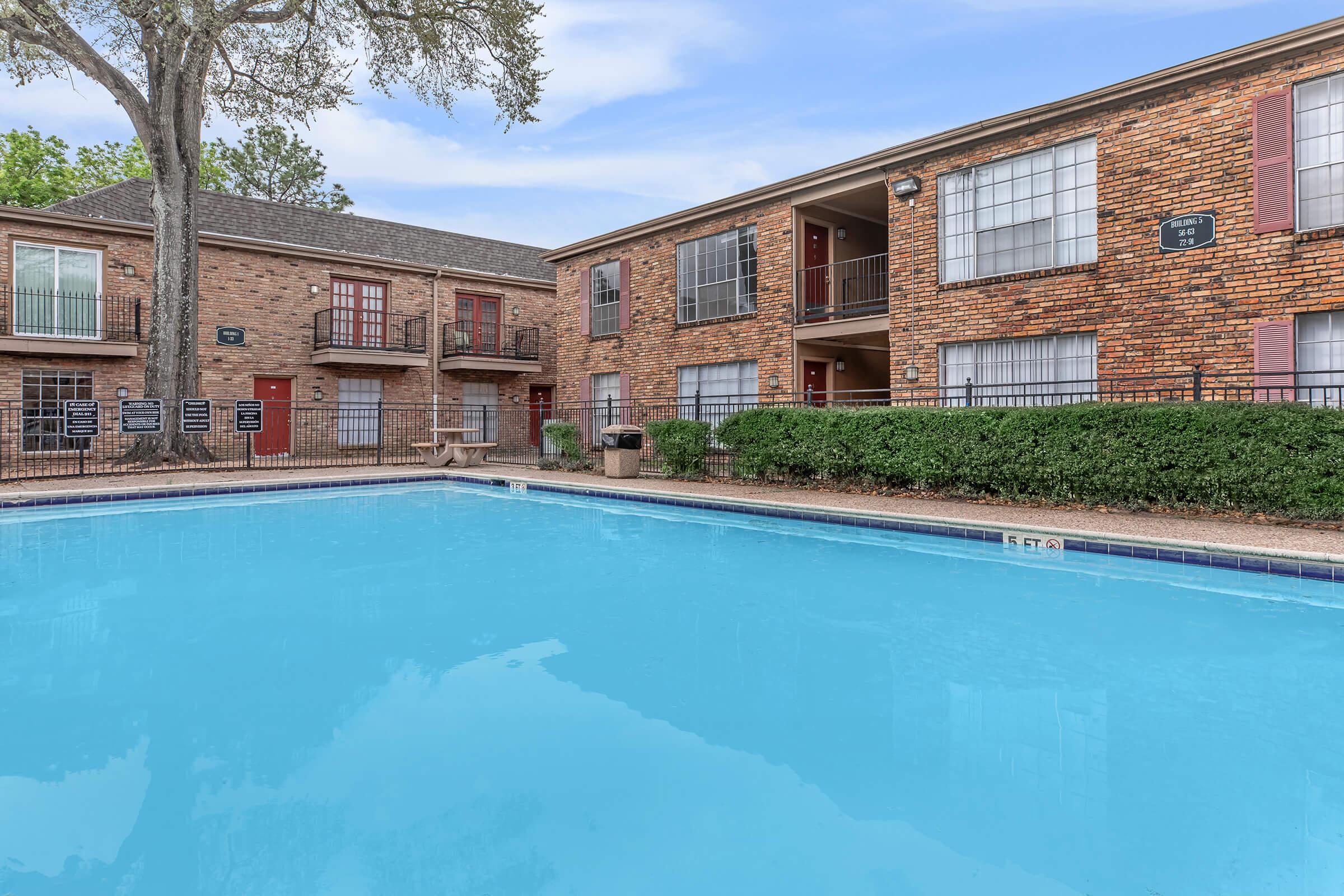 a large brick building with a pool of water