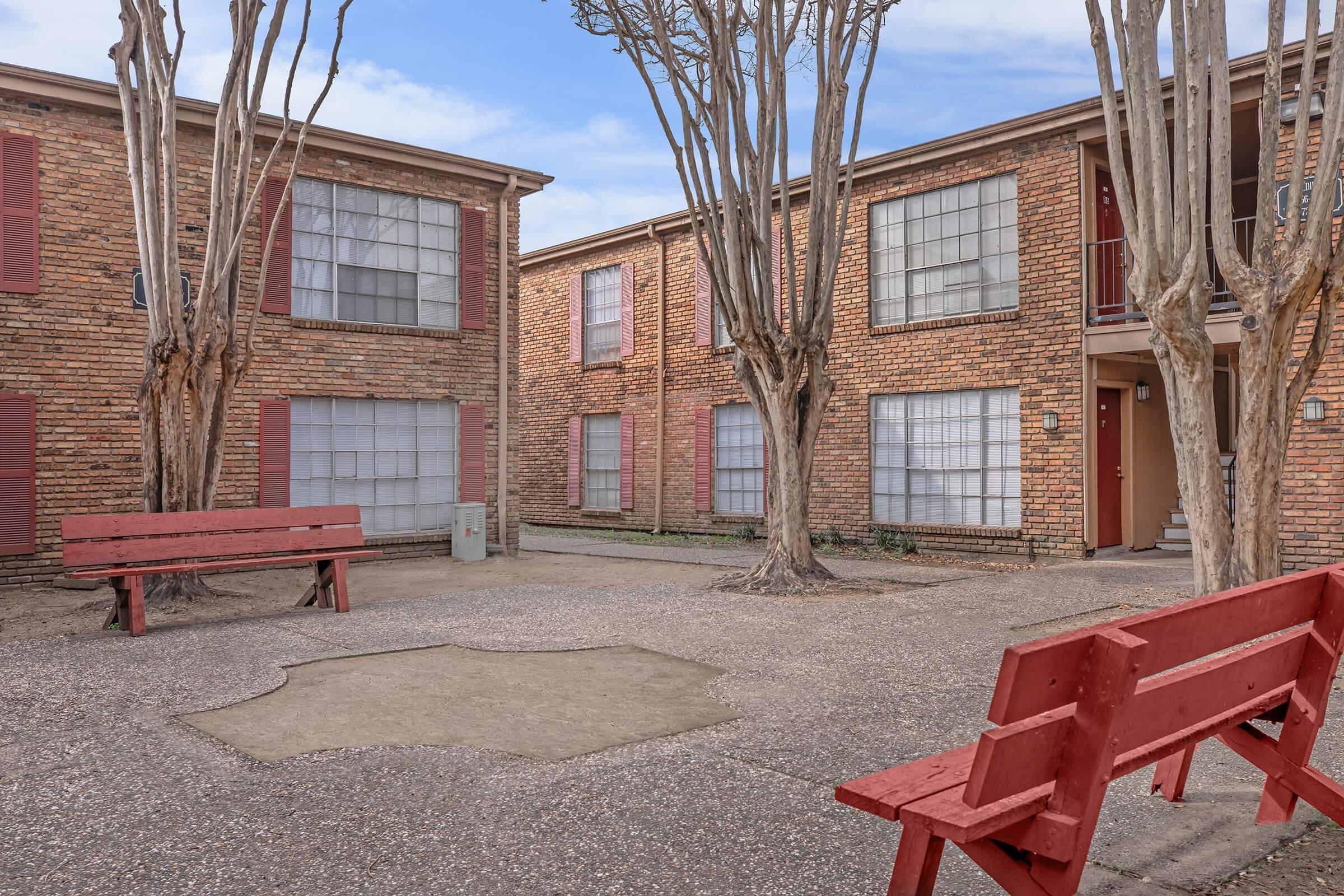 a wooden bench sitting in front of a brick building