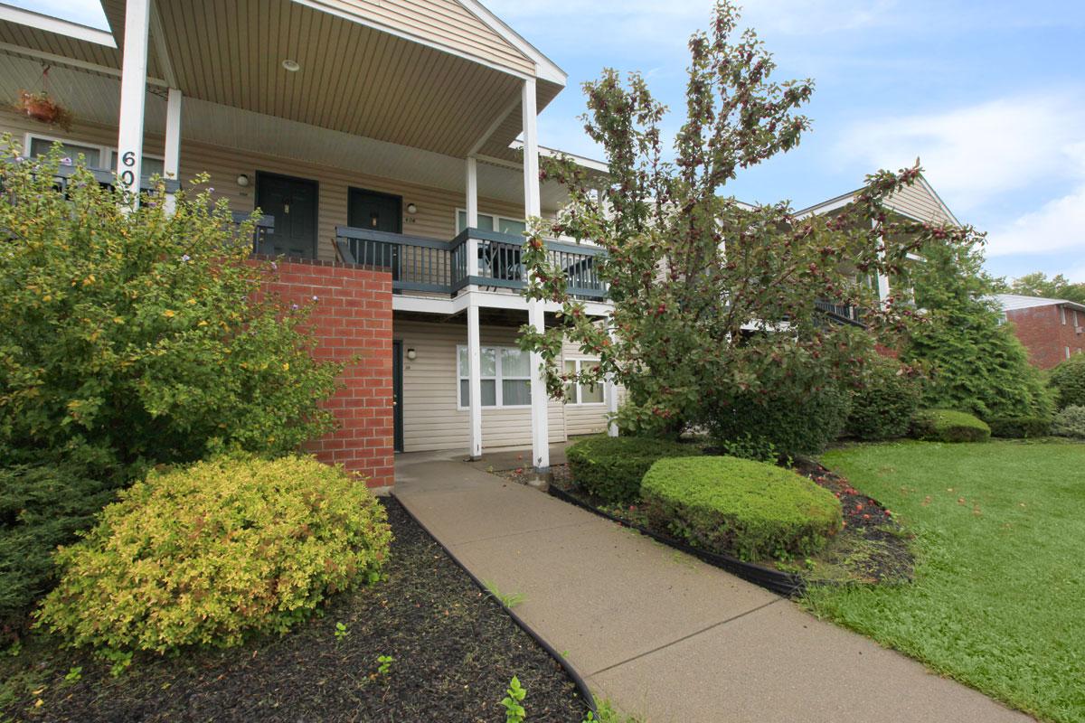 a large brick building with grass in front of a house