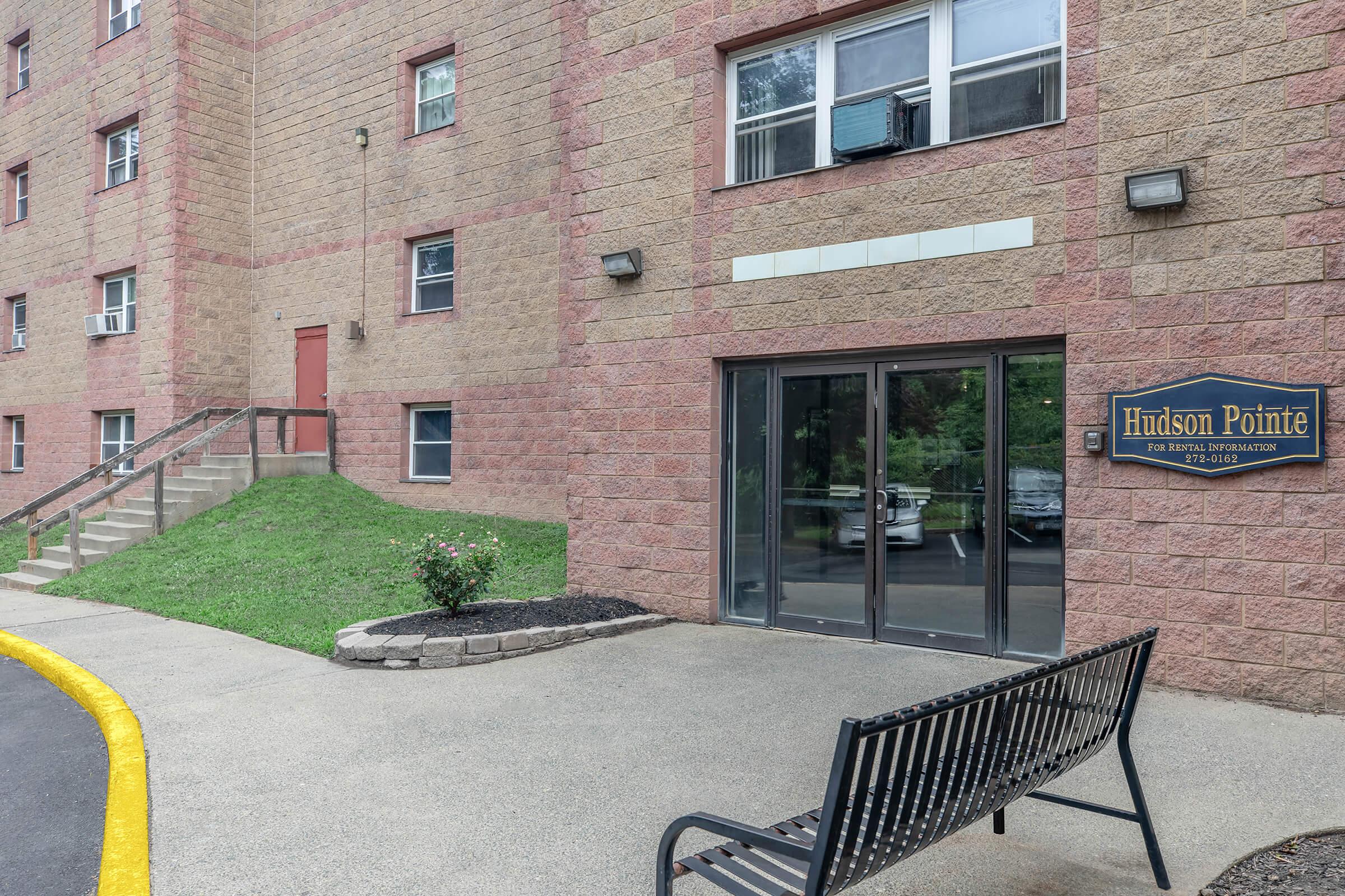 a bench in front of a brick building