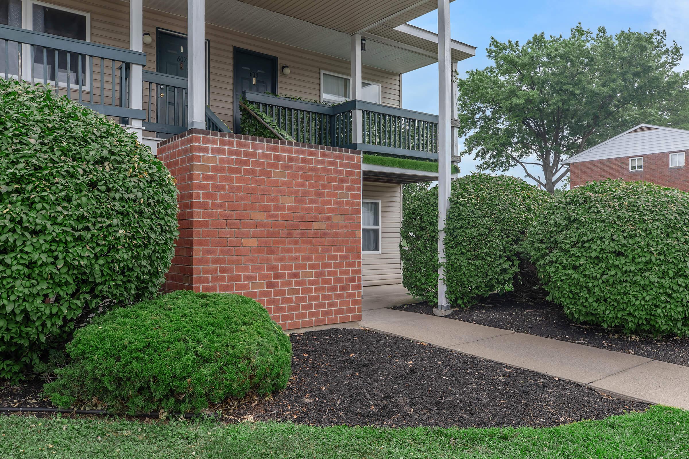 a garden in front of a brick building