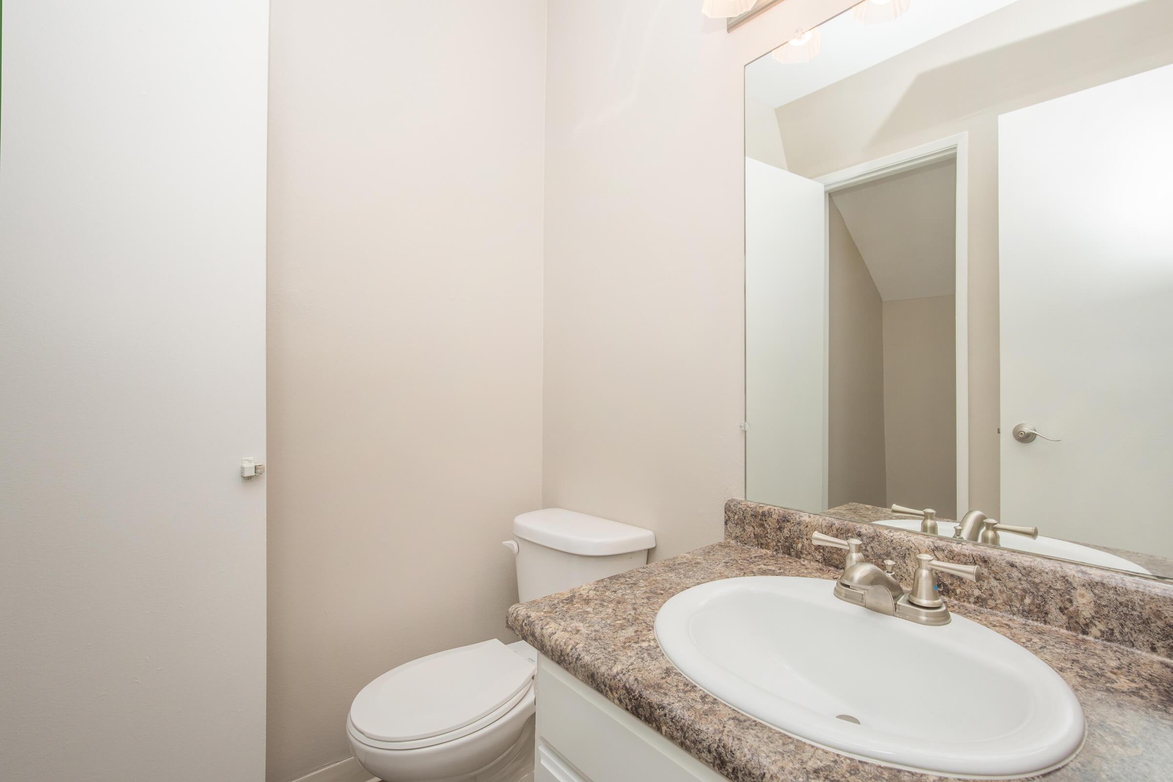 Half bathroom with white cabinets