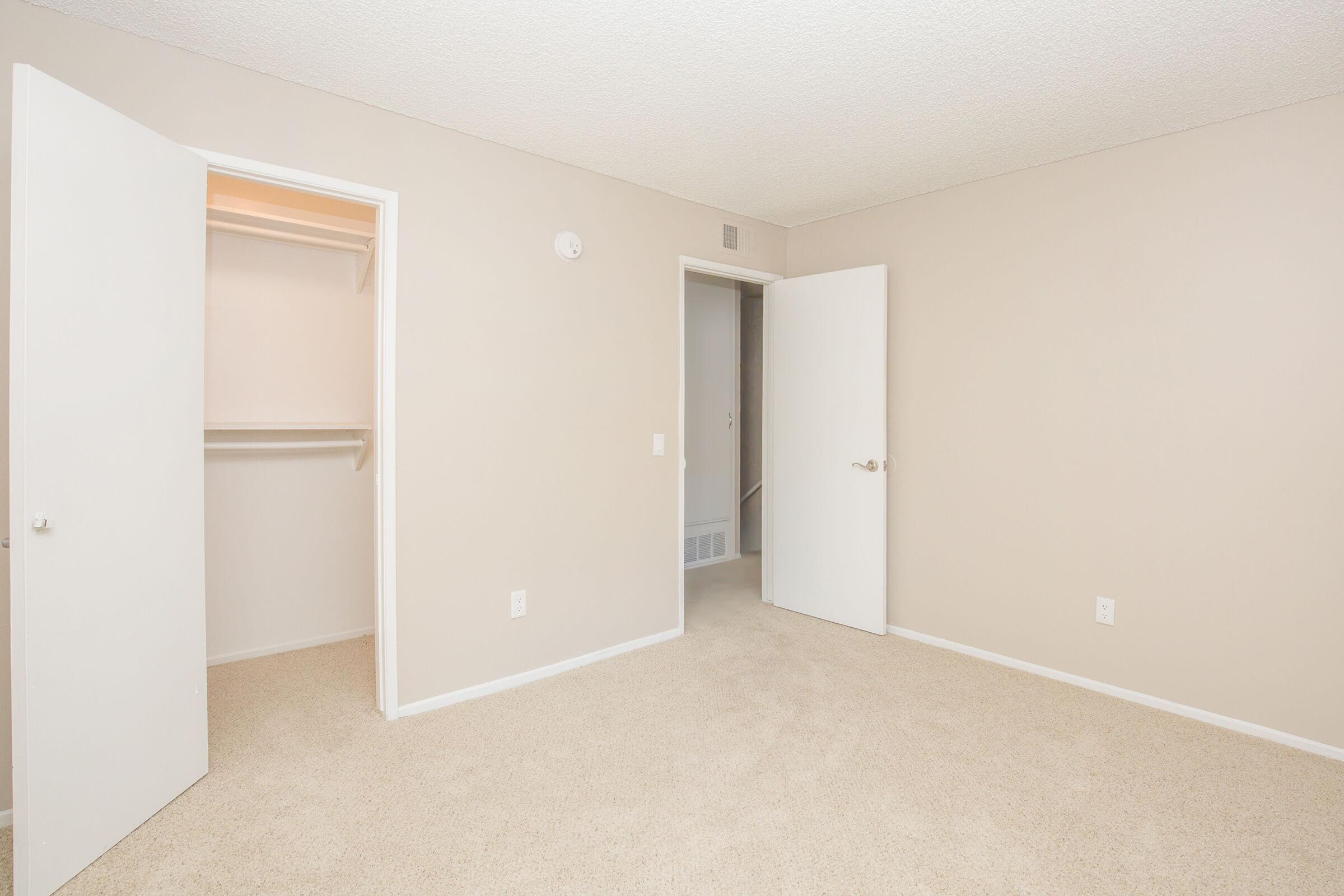 Carpeted bedroom with open closet door