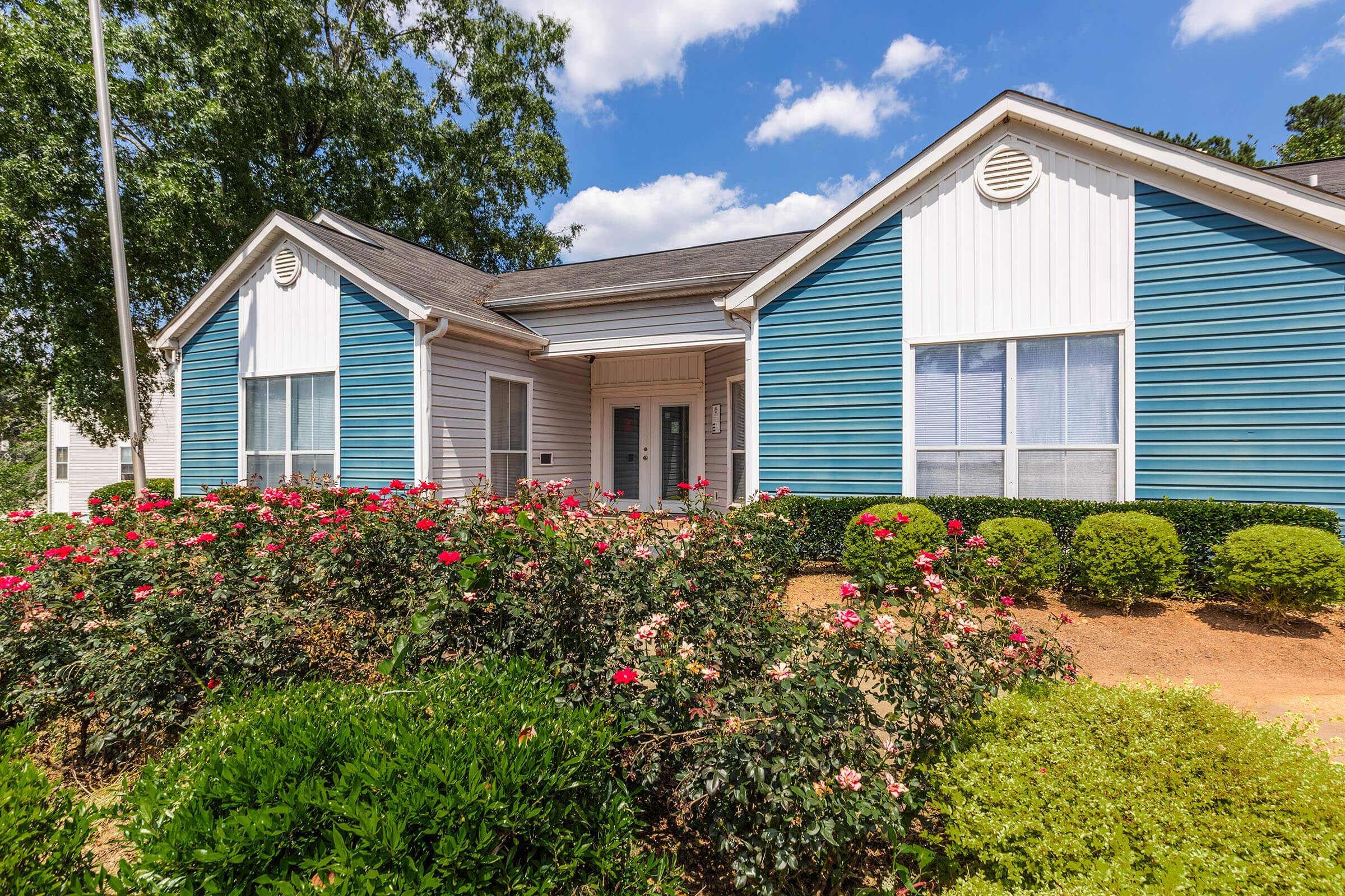 a close up of a flower garden in front of a house