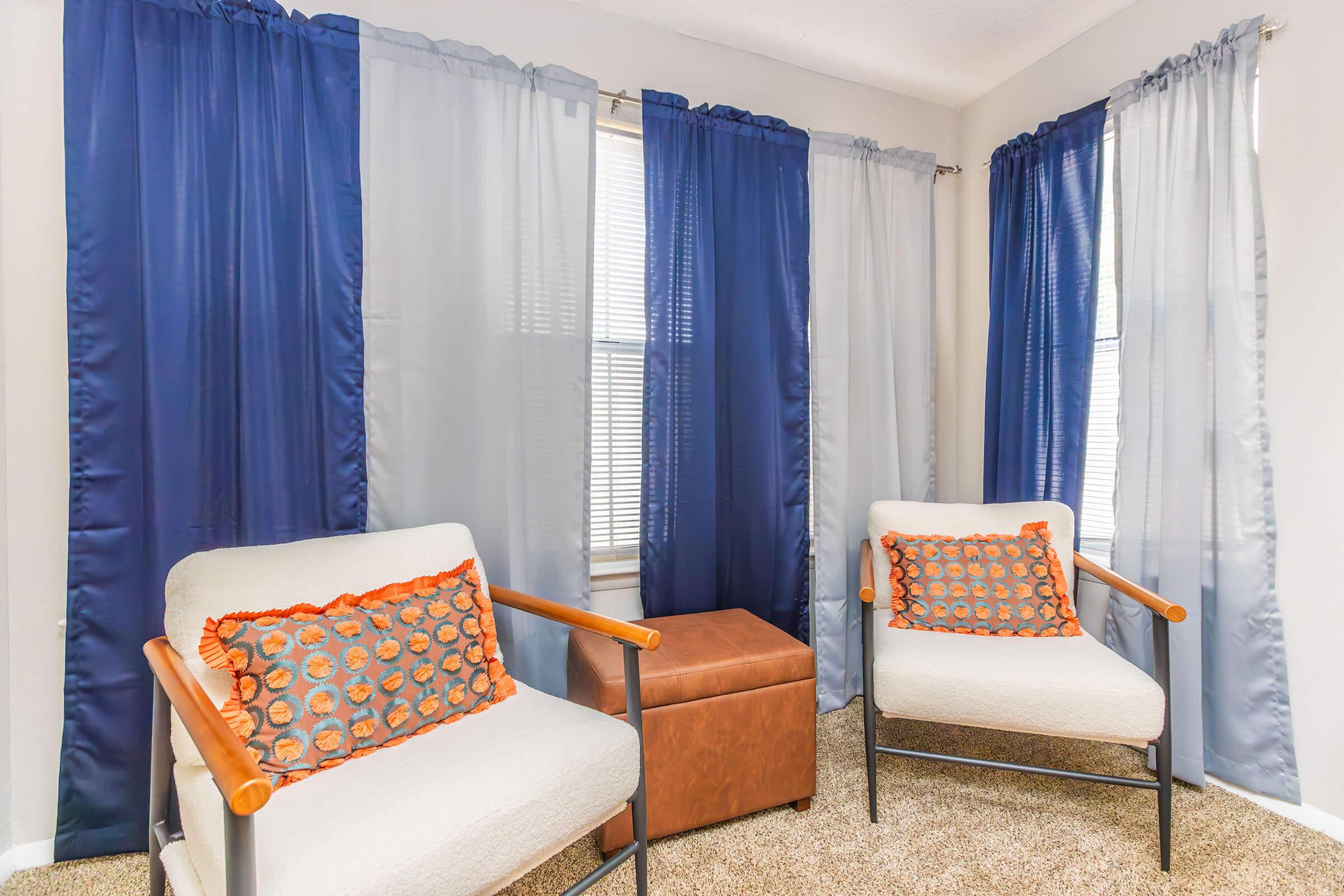 a room filled with furniture and a blue curtain