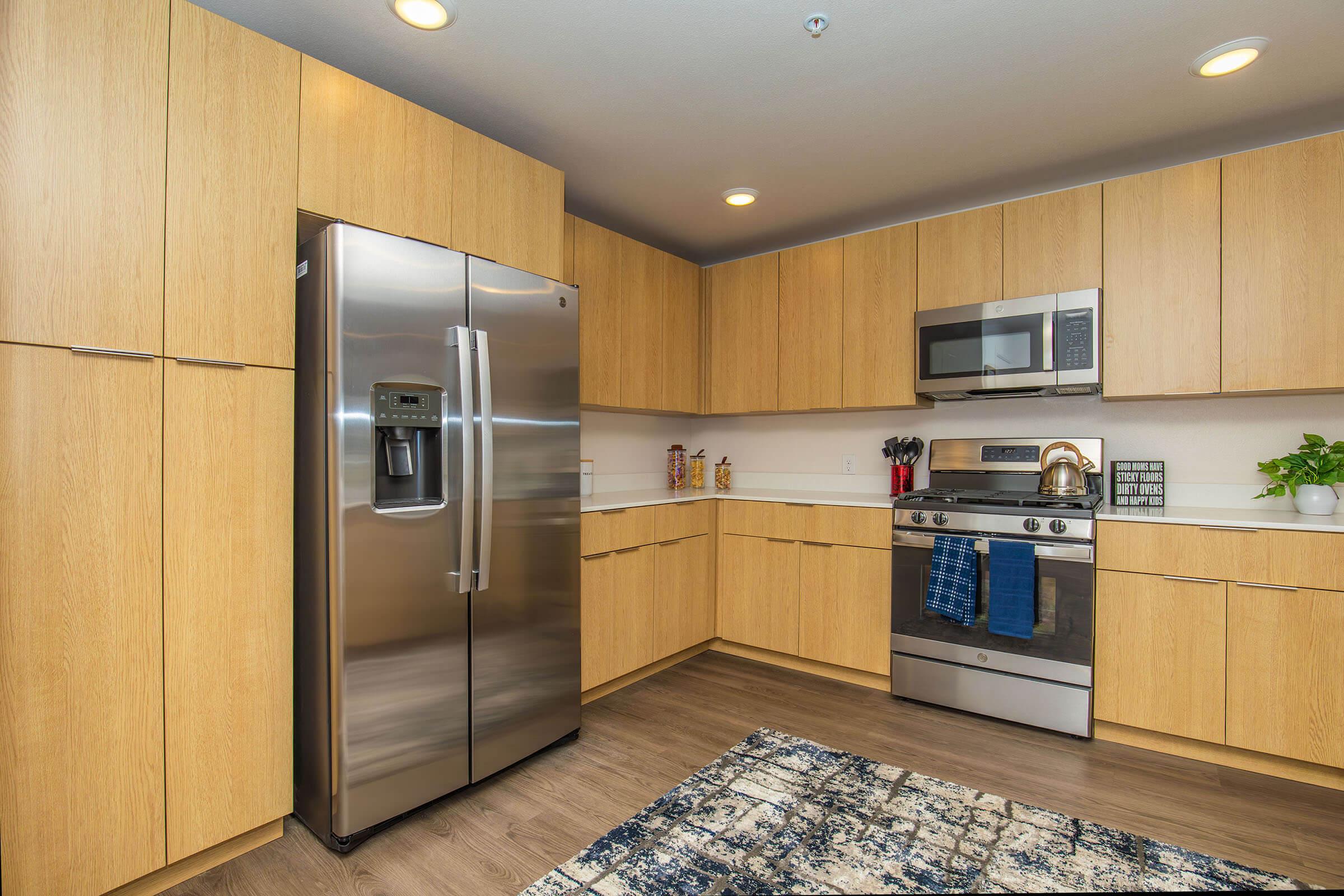 a modern kitchen with stainless steel appliances and wooden cabinets