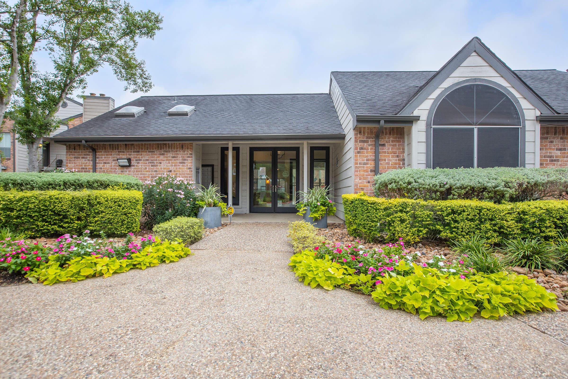 a close up of a flower garden in front of a house