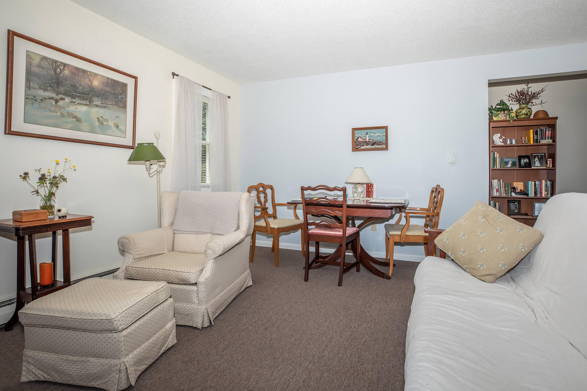 a bedroom with a bed and chair in the living room