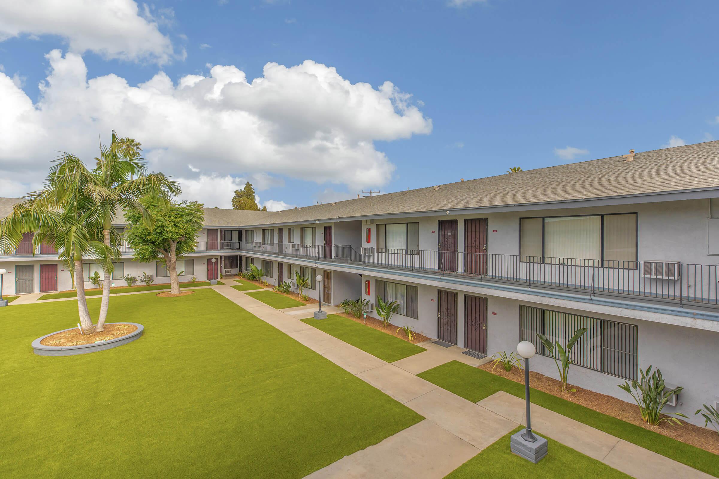 Miramar Apartments community building with a green tree