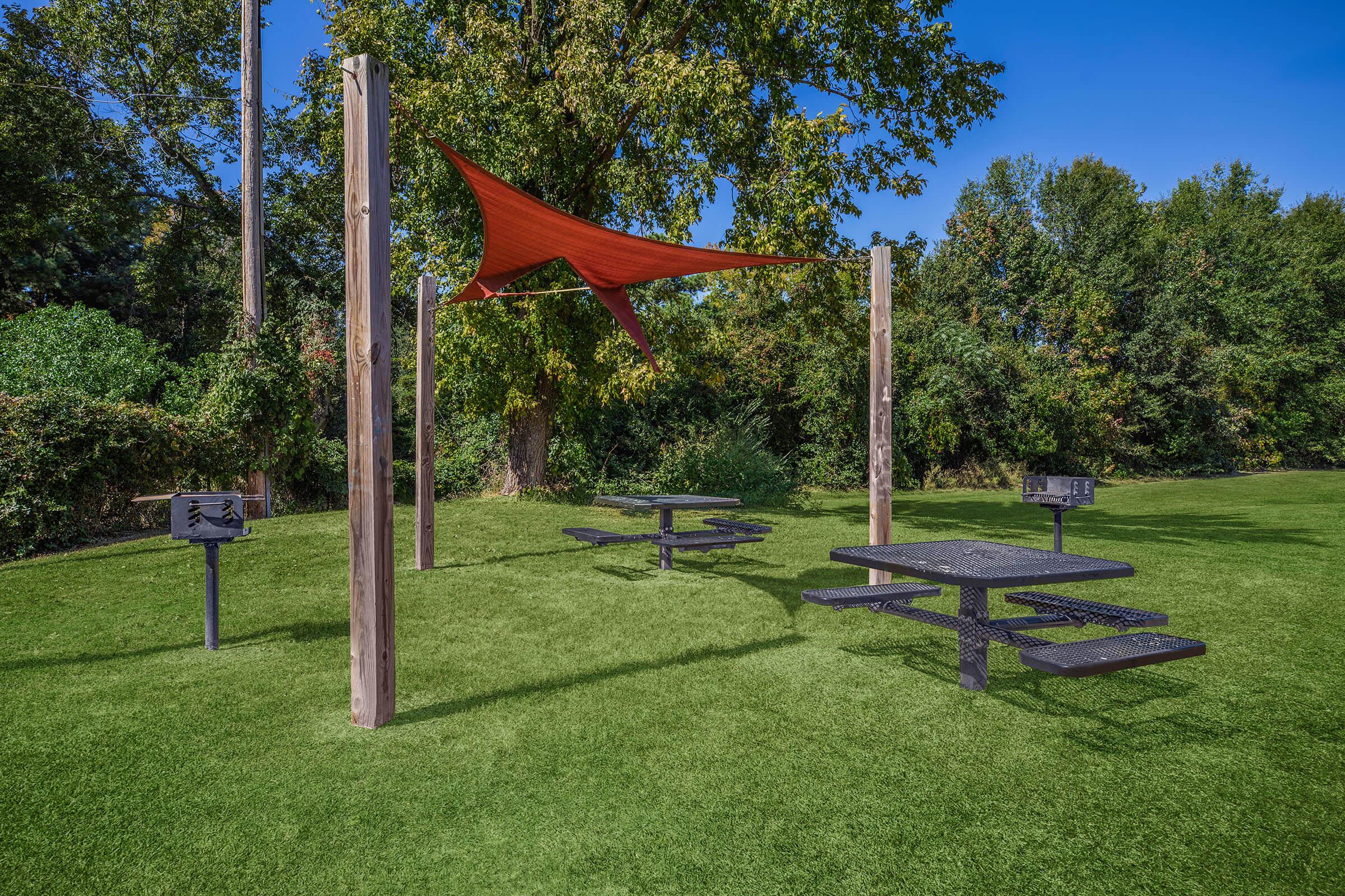 a group of lawn chairs sitting on top of a grass covered field