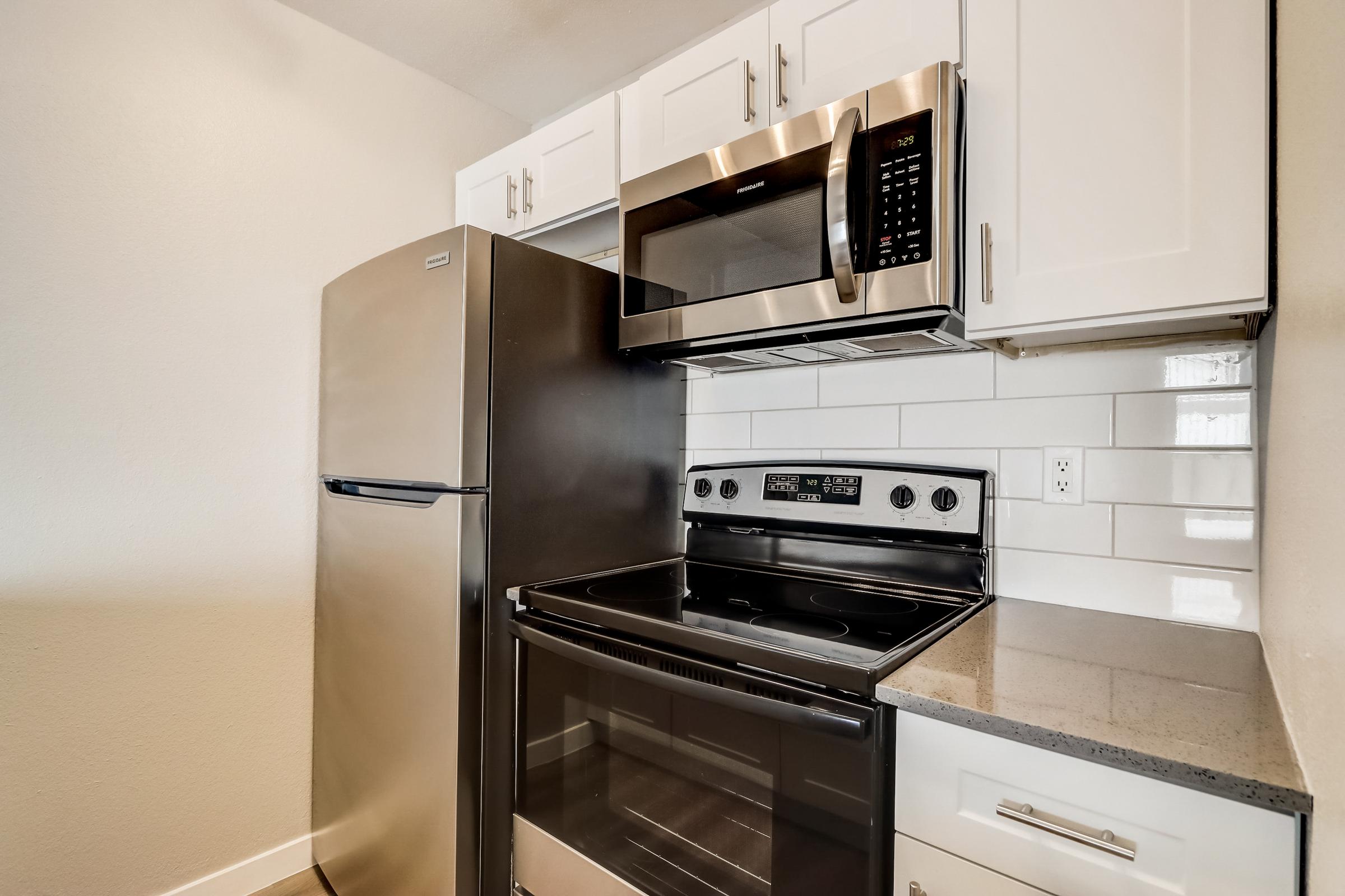 A kitchen with a stainless steel stove and refrigerator at Rise at the Lofts. 