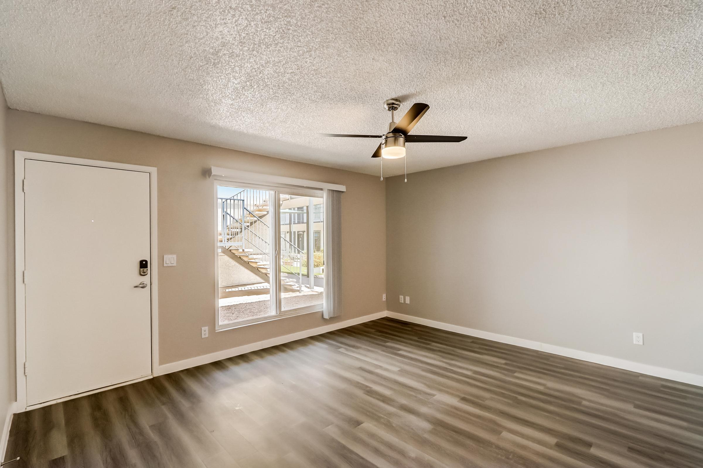 A kitchen and living area with wooden floors at a Rise at the Lofts apartment. 