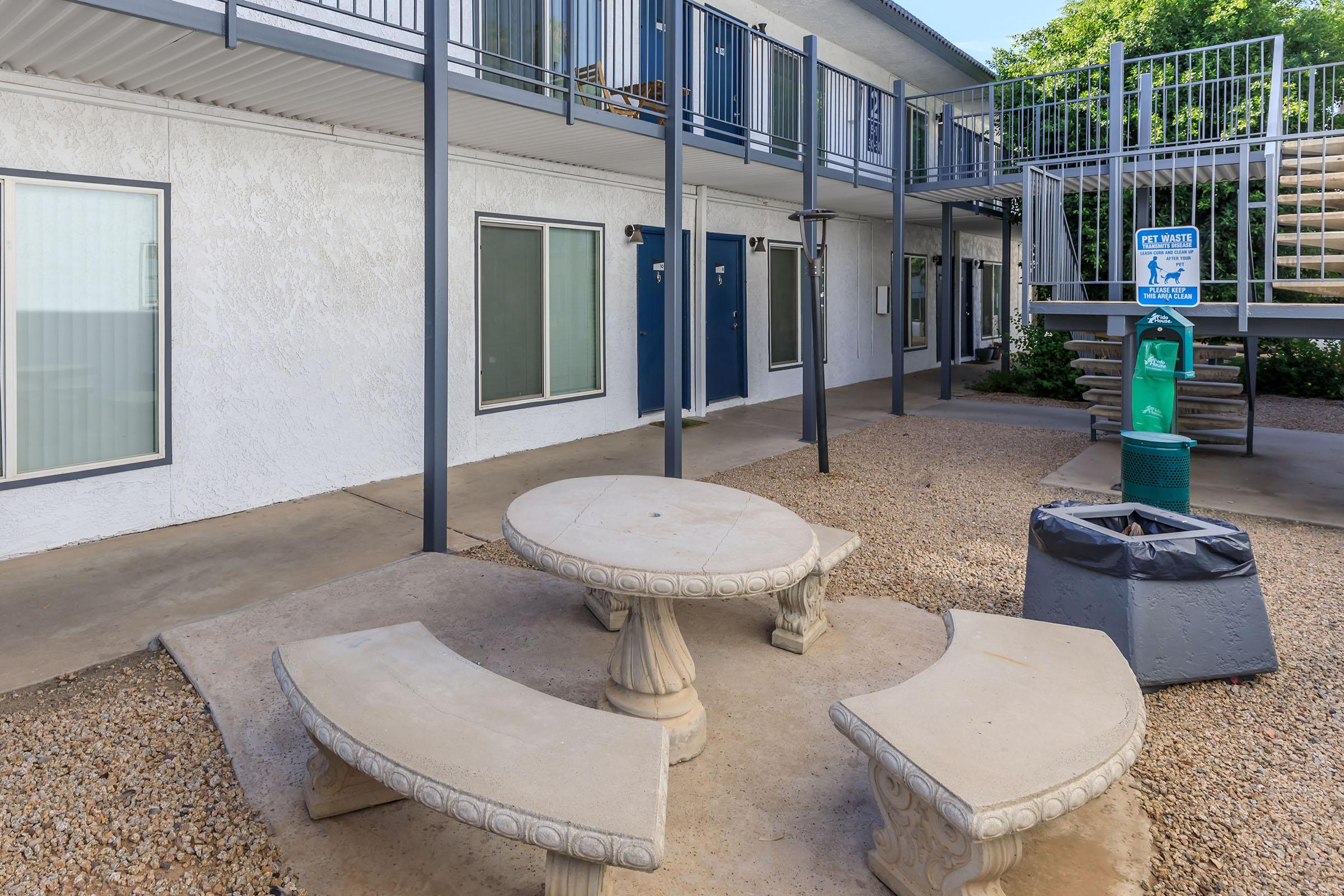 A cement outdoor table with seating in the Rise at the Lofts courtyard. 