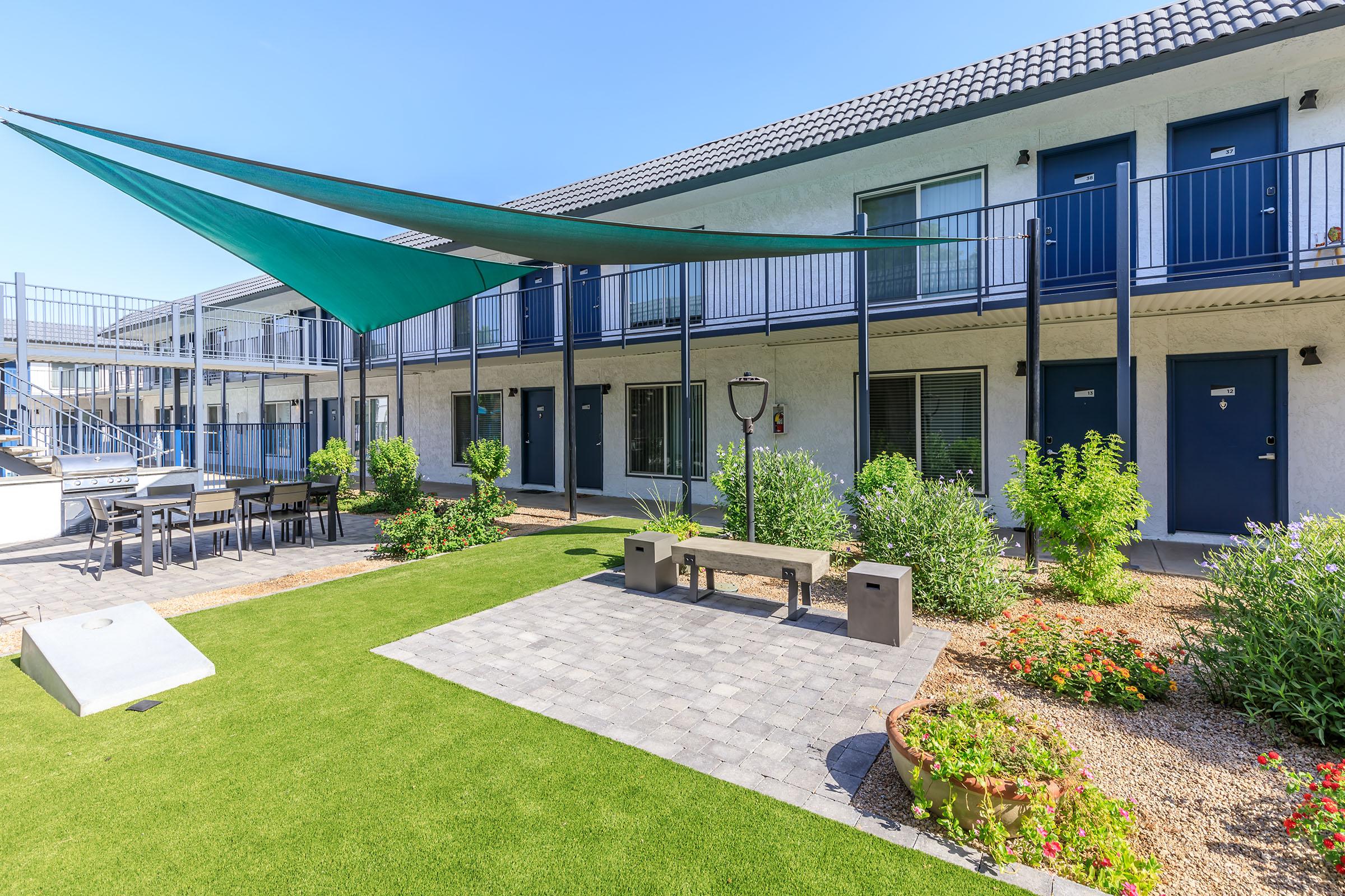 Exterior courtyard at Rise at the Lofts with large grass recreation area. 