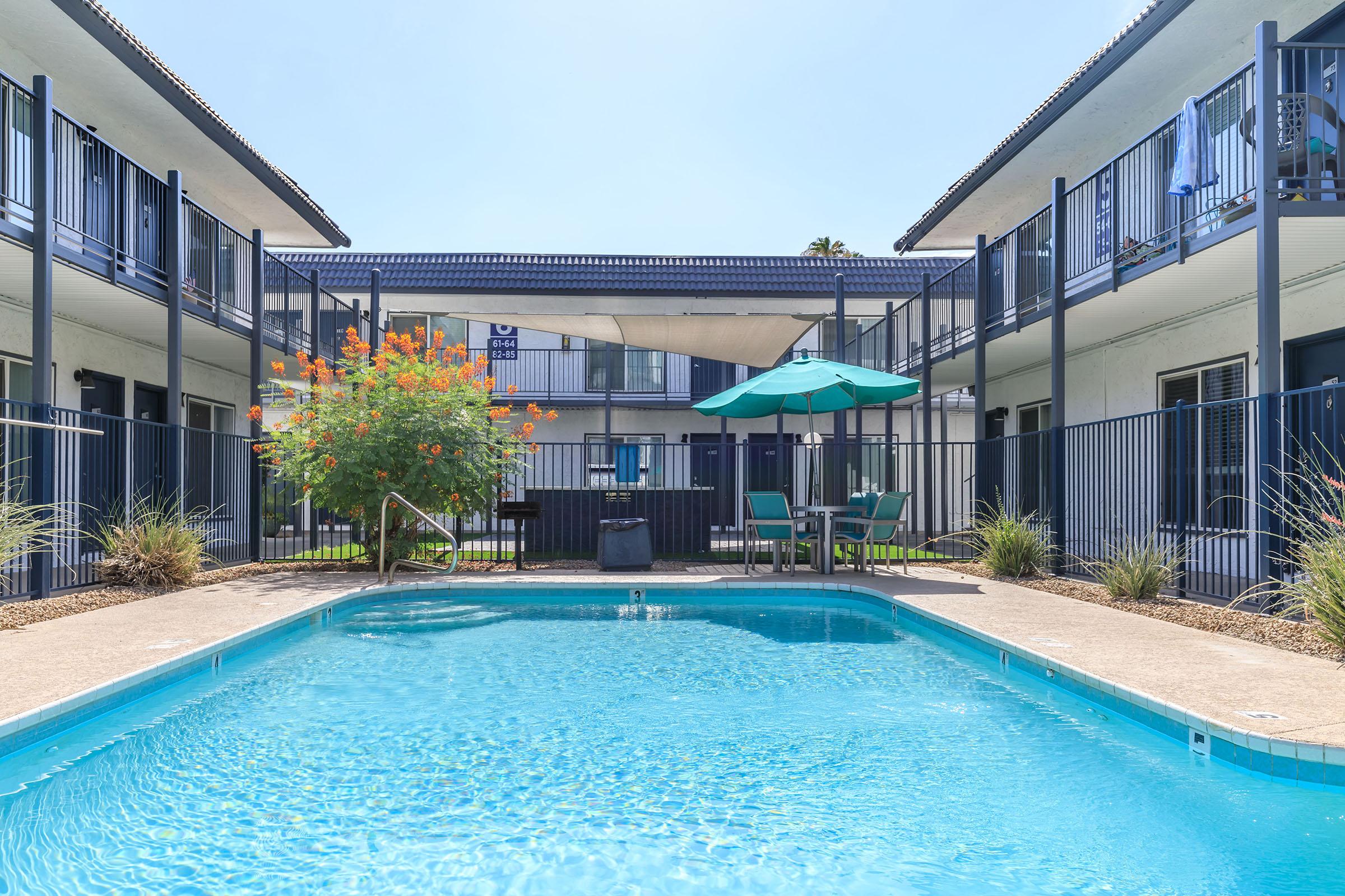 Rise at the Lofts blue outdoor swimming pool with apartment balconies surrounding it.