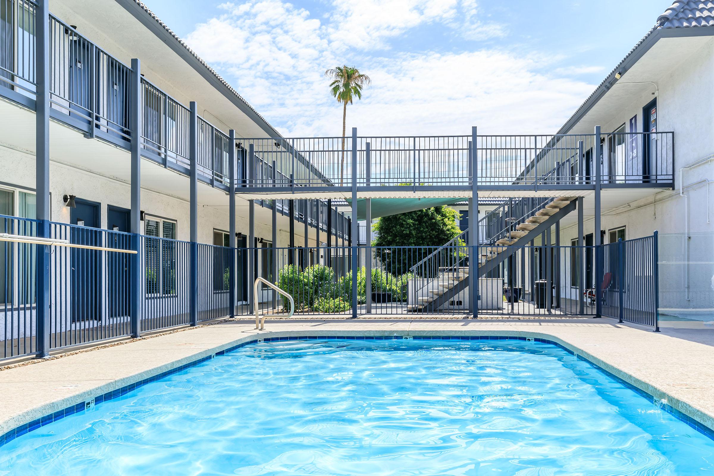 Rise at the Lofts outdoor apartment walkway over a large blue outdoor pool.