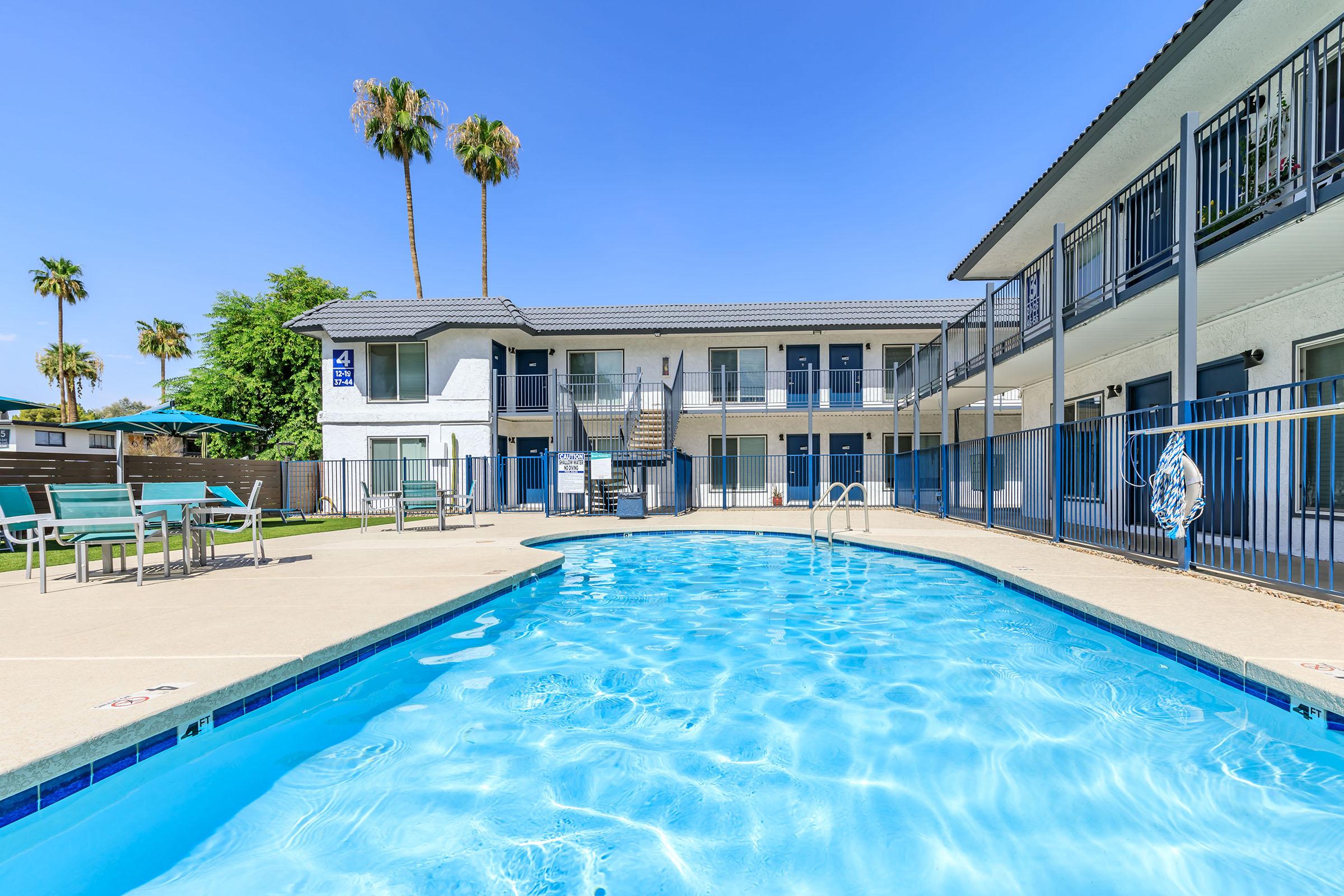 Outdoor resort style swimming pool surrounded by the apartments at Rise at the Lofts. 