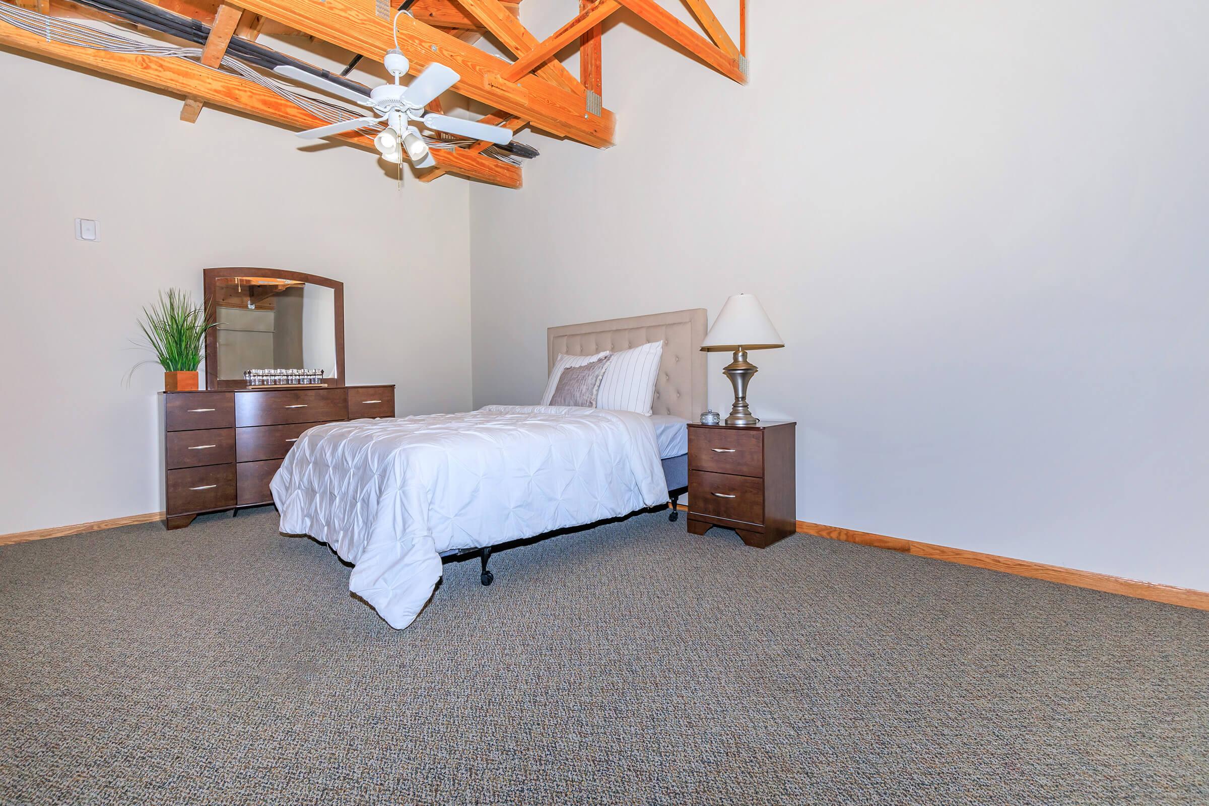 a bedroom with a bed and desk in a room