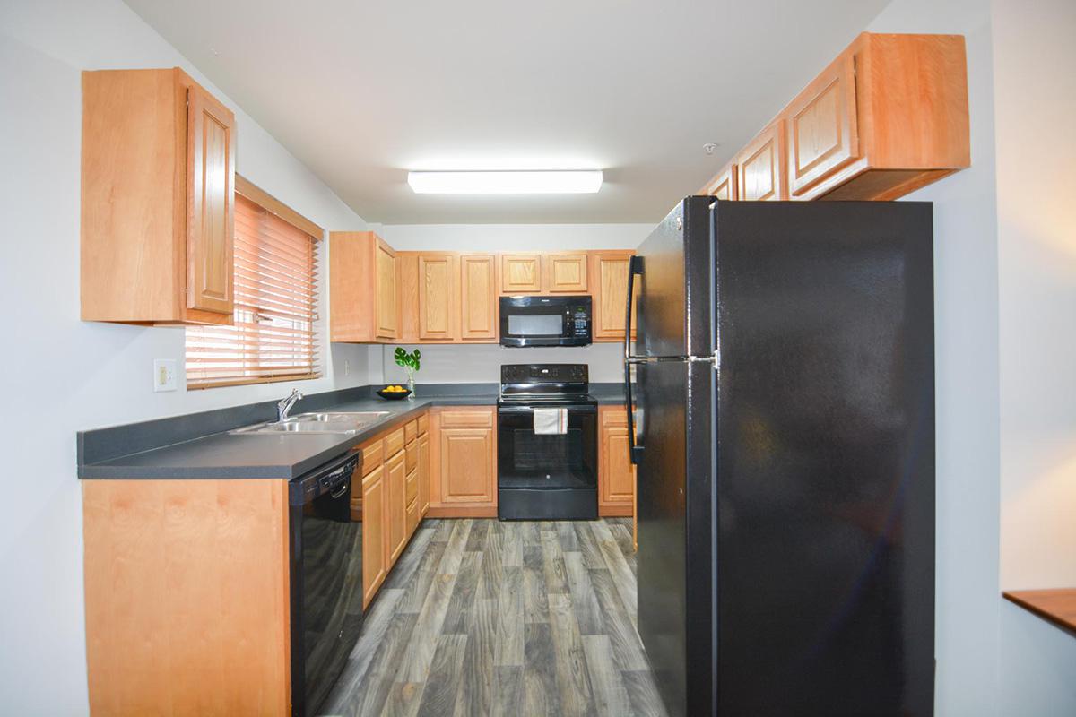 a large kitchen with stainless steel appliances and wooden cabinets