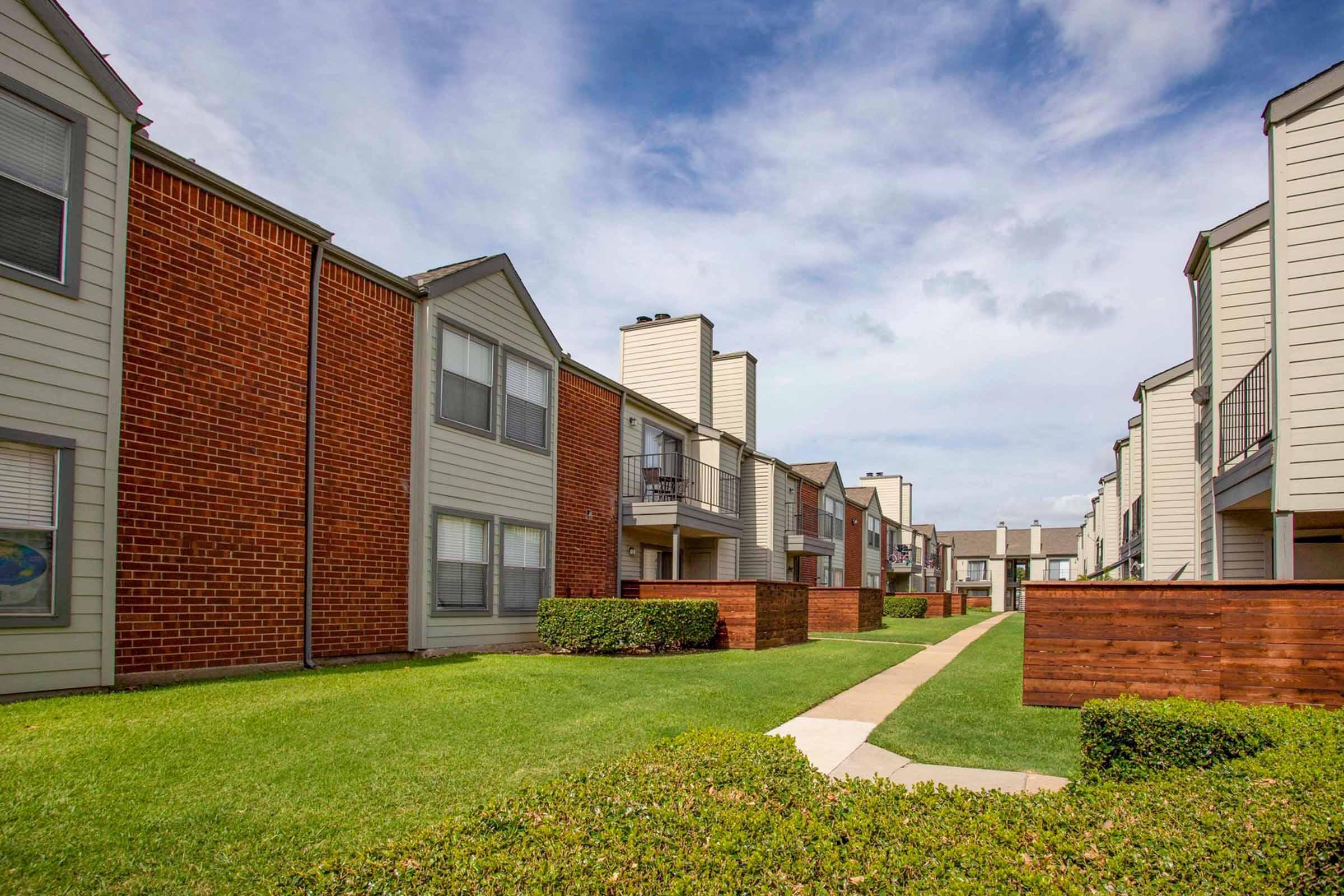 a large lawn in front of a brick building