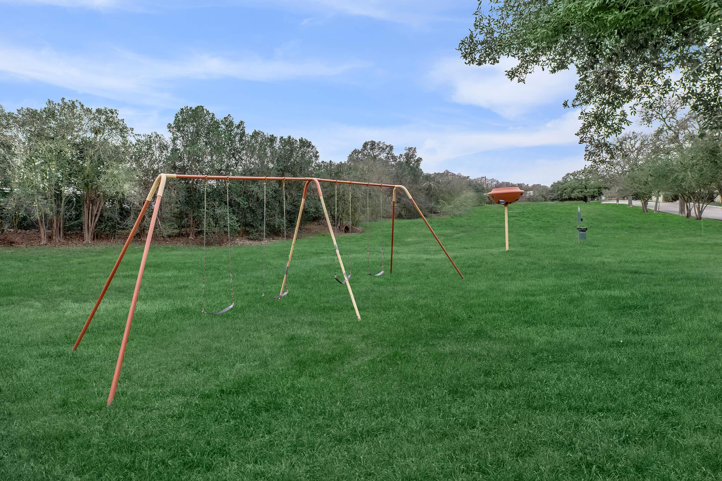 a swing set in a grassy field