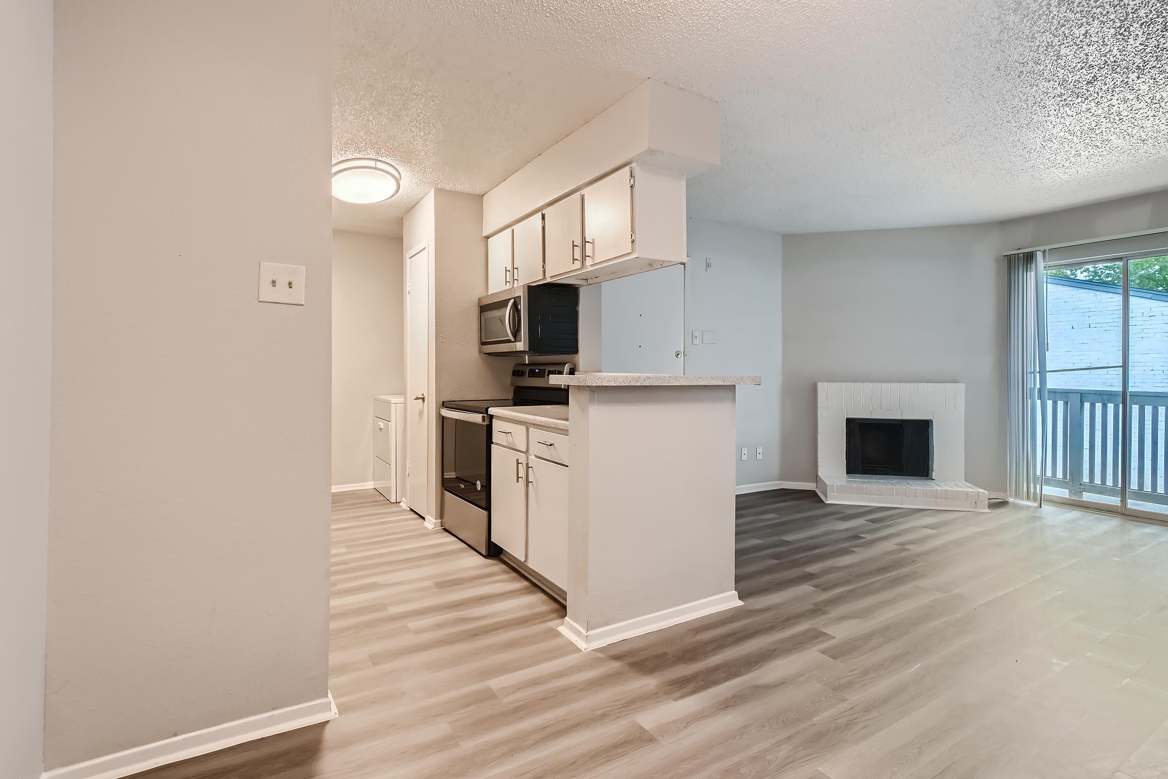Wood-style flooring throughout the open-concept living area and kitchen in a Rise North Arlington apartment.