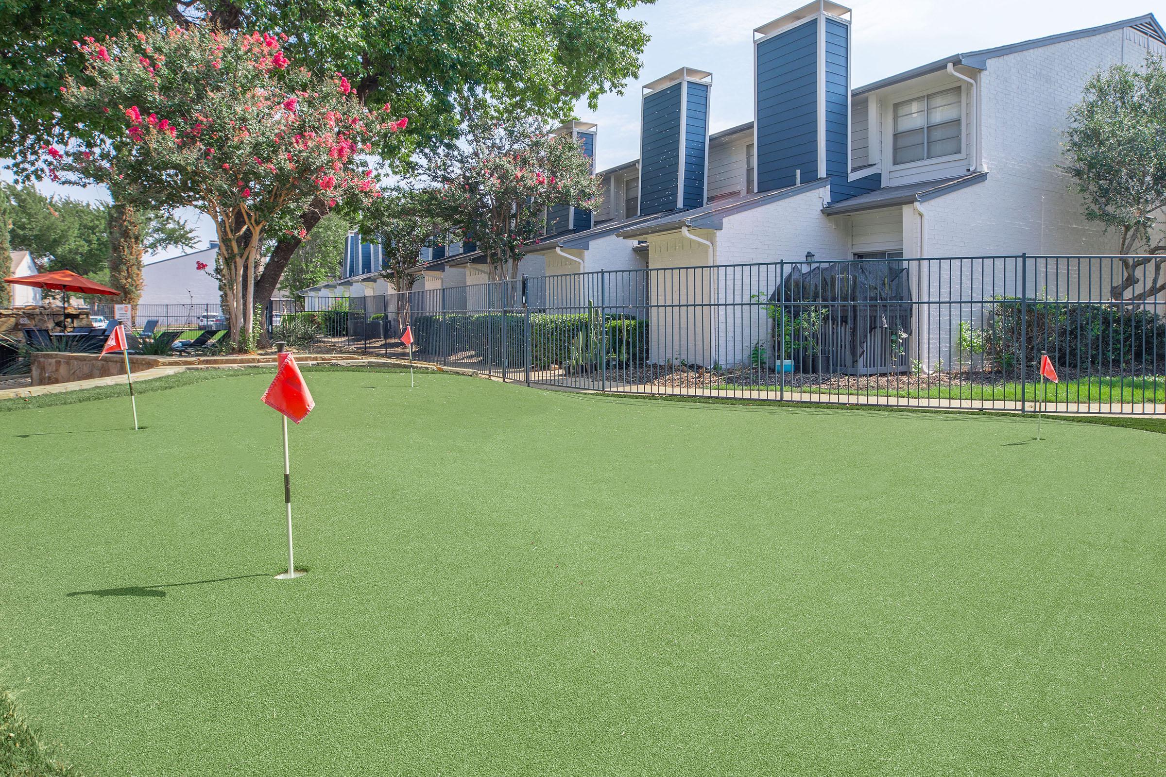 A mini golf area in the courtyard surrounded by the apartments at Rise North Arlington.