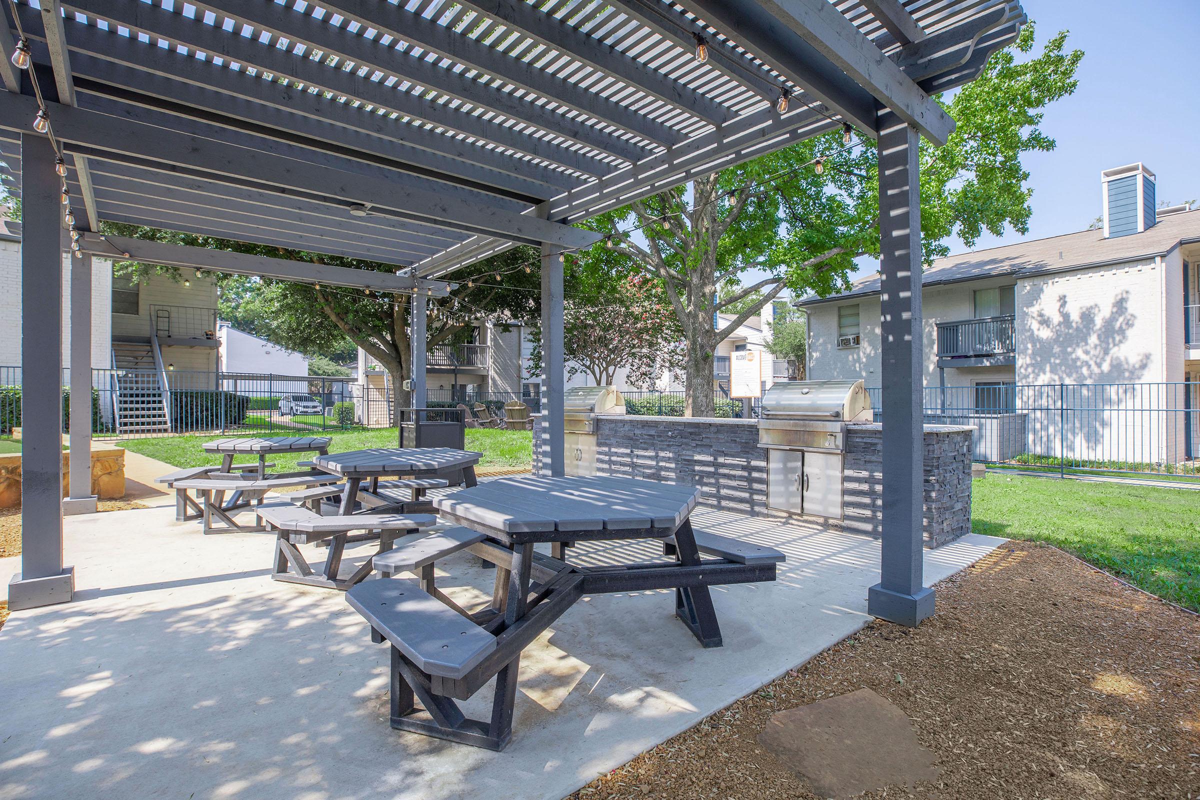 The BBQ area with grills and tables and benches at Rise North Arlington.