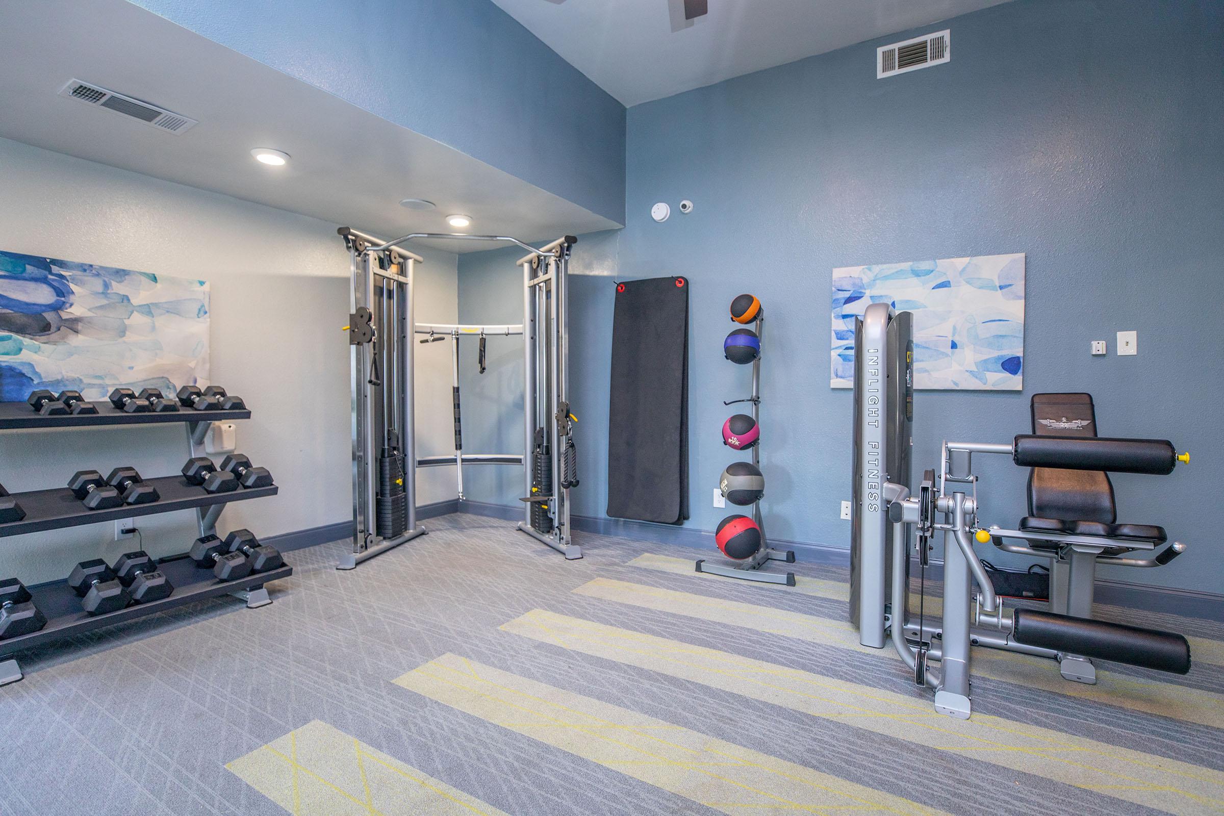 The fitness center with carpeting and equipment at Rise North Arlington.